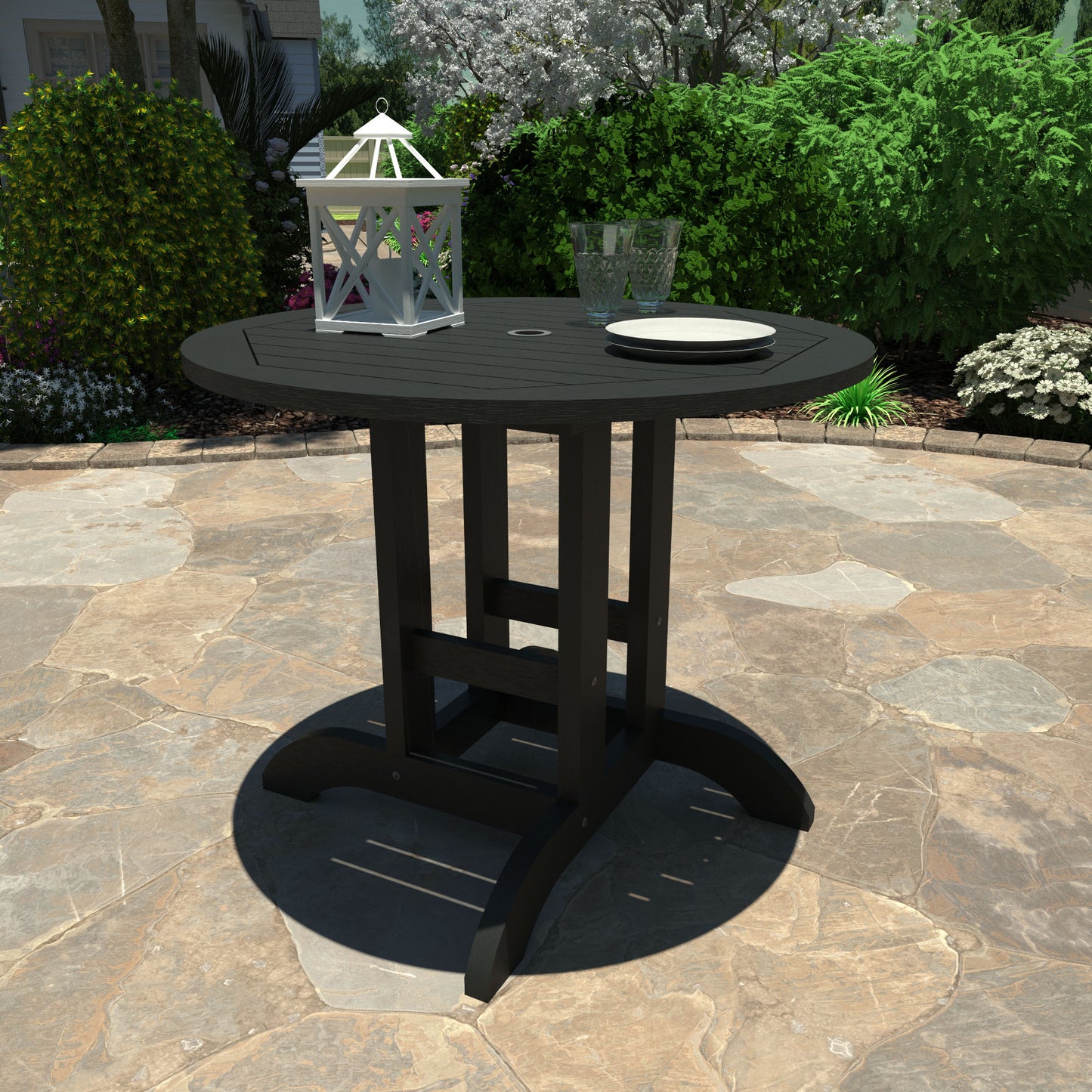 Black 36” diameter dining height table with lantern, plates, and glasses