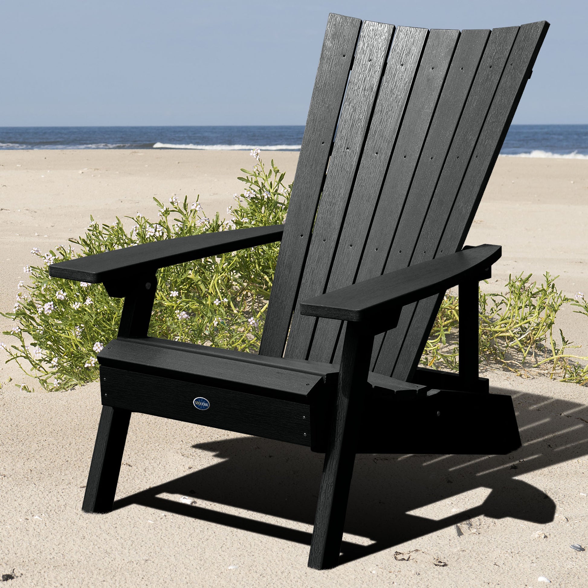 Black Granite Hills folding and reclining Adirondack chair on a beach