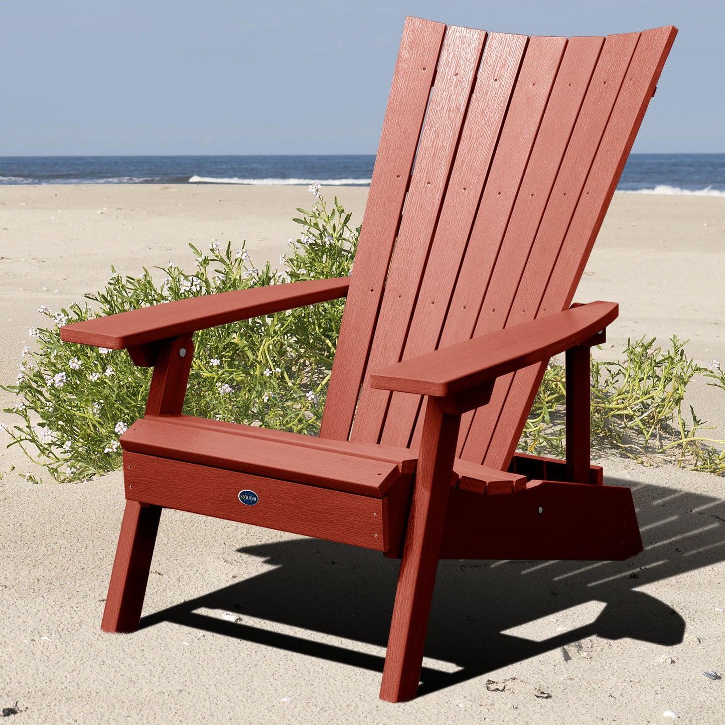 Red Granite Hills folding and reclining Adirondack chair on a beach