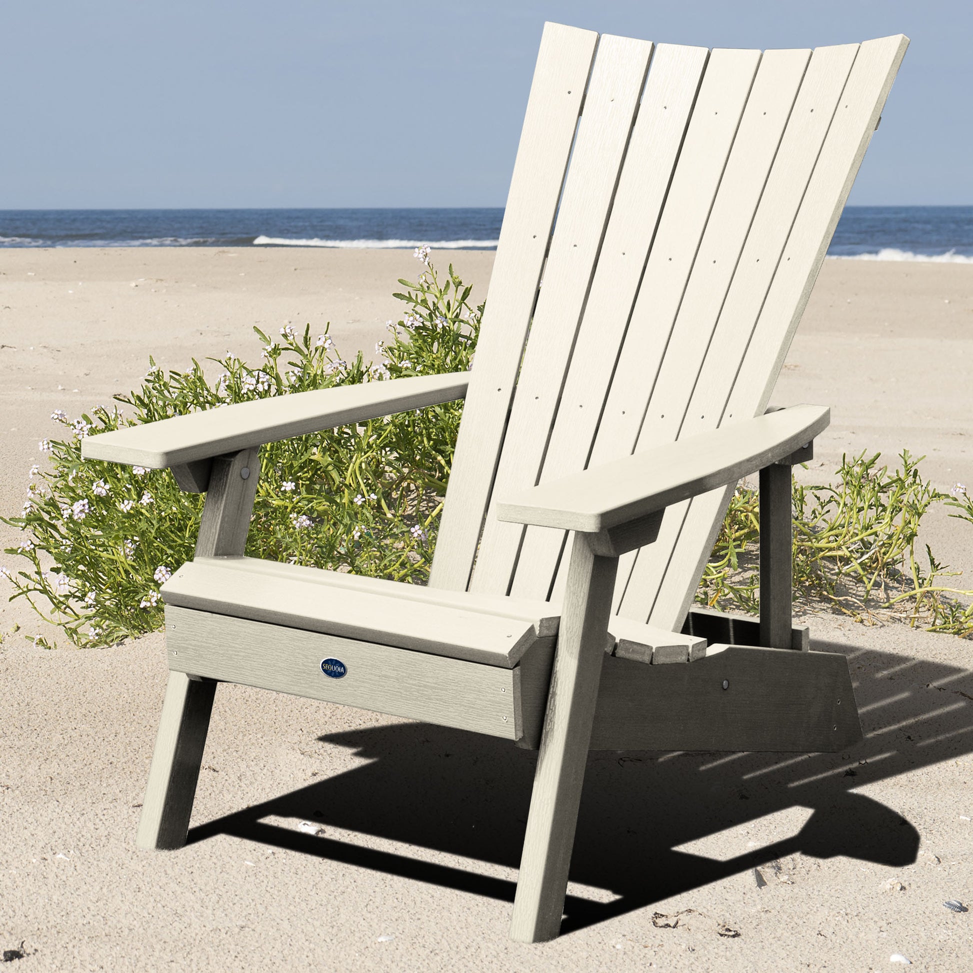 Whitewash Granite Hills folding and reclining Adirondack chair on a beach