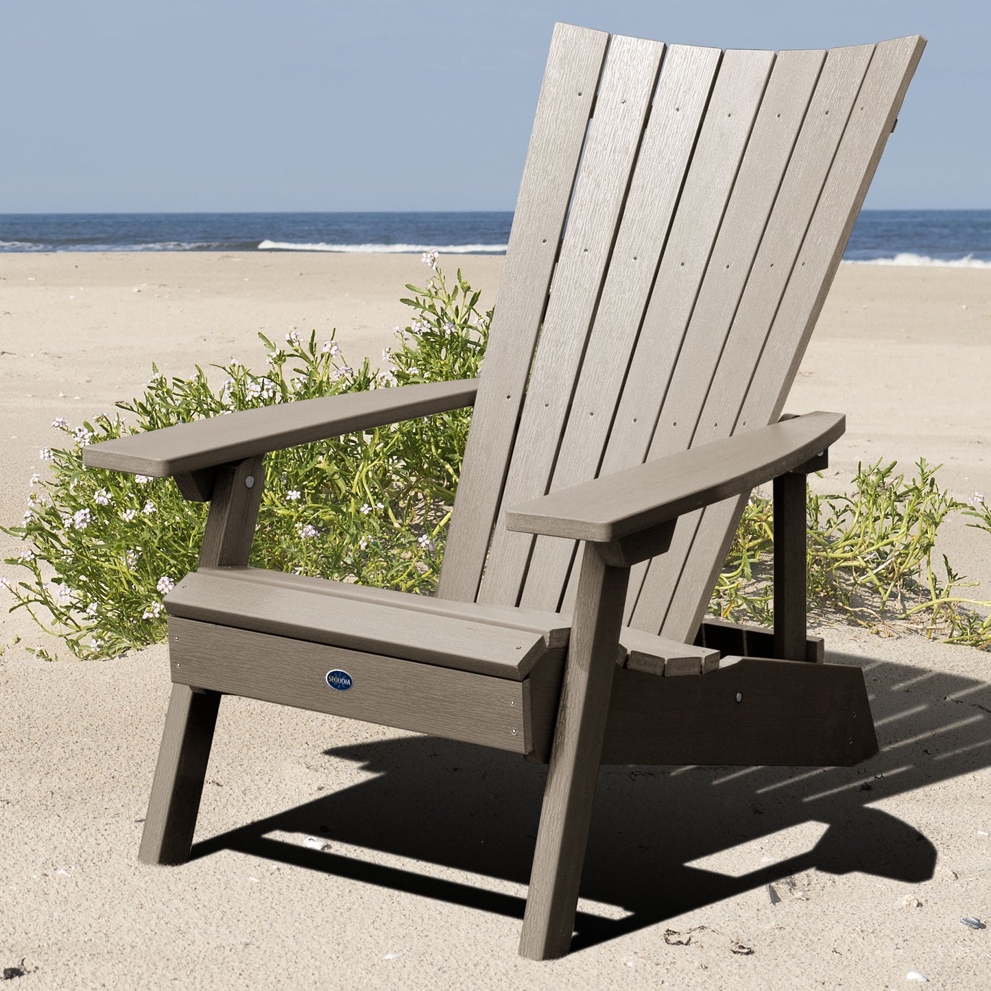 Light brown Granite Hills folding and reclining Adirondack chair on a beach