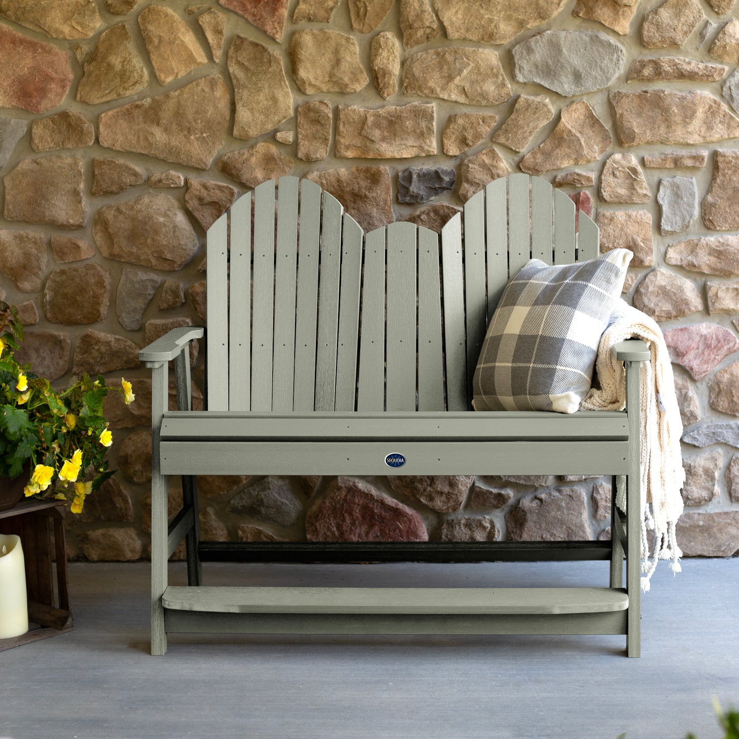 Light green Lighthouse counter height Adirondack bench against stone wall