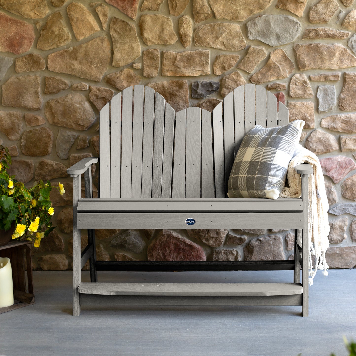 Light gray Lighthouse counter height Adirondack bench against stone wall