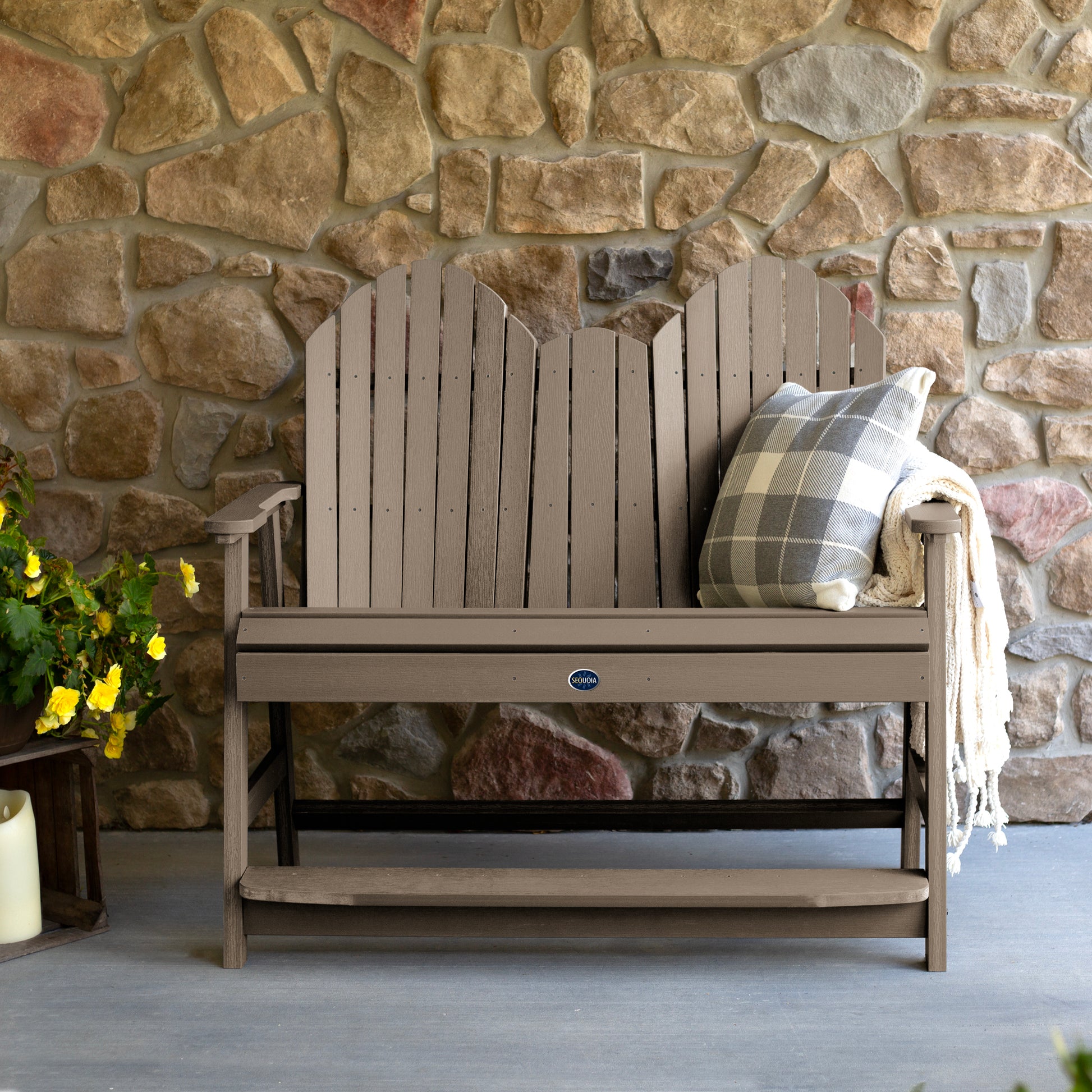 Light brown Lighthouse counter height Adirondack bench against stone wall