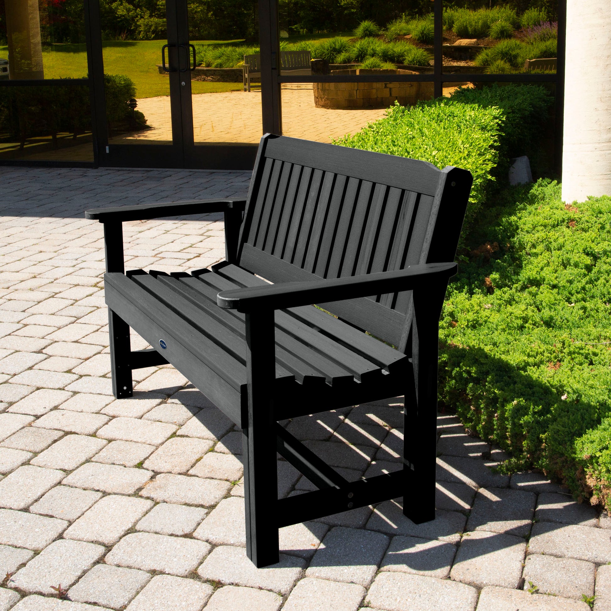 Black 4ft Blue Ridge Commercial Garden Bench on stone pathway