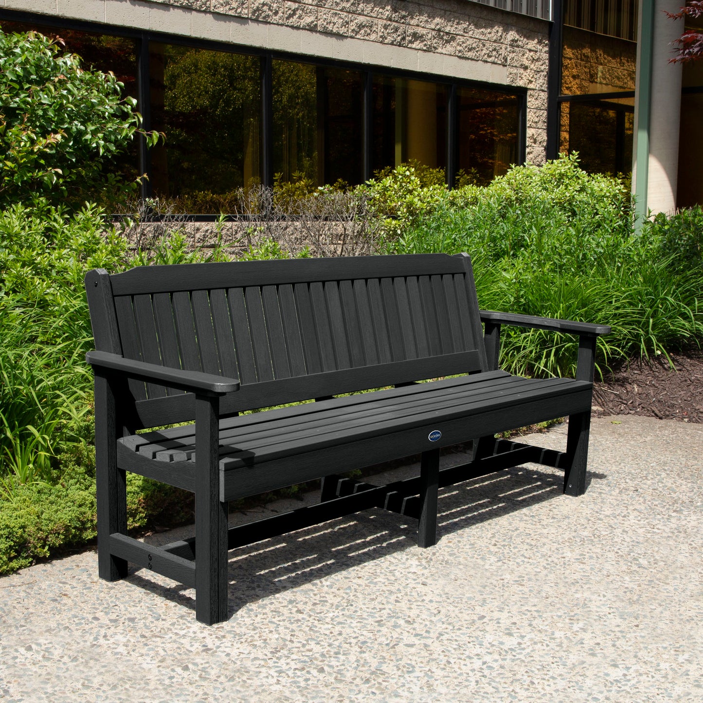 Black 6ft Blue Ridge Garden Bench with bushes in background
