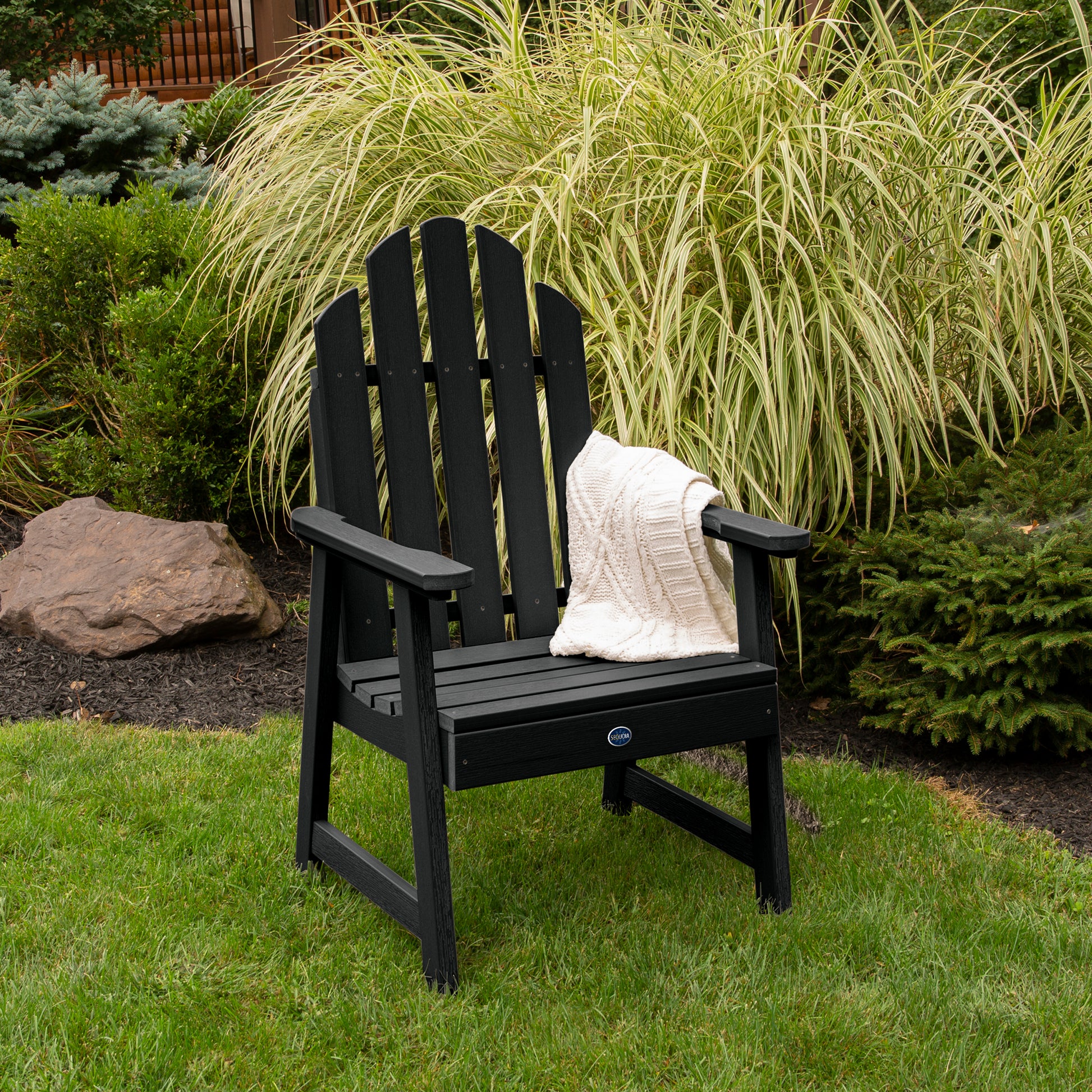 Black Lighthouse Garden Chair on grass in front of bushes