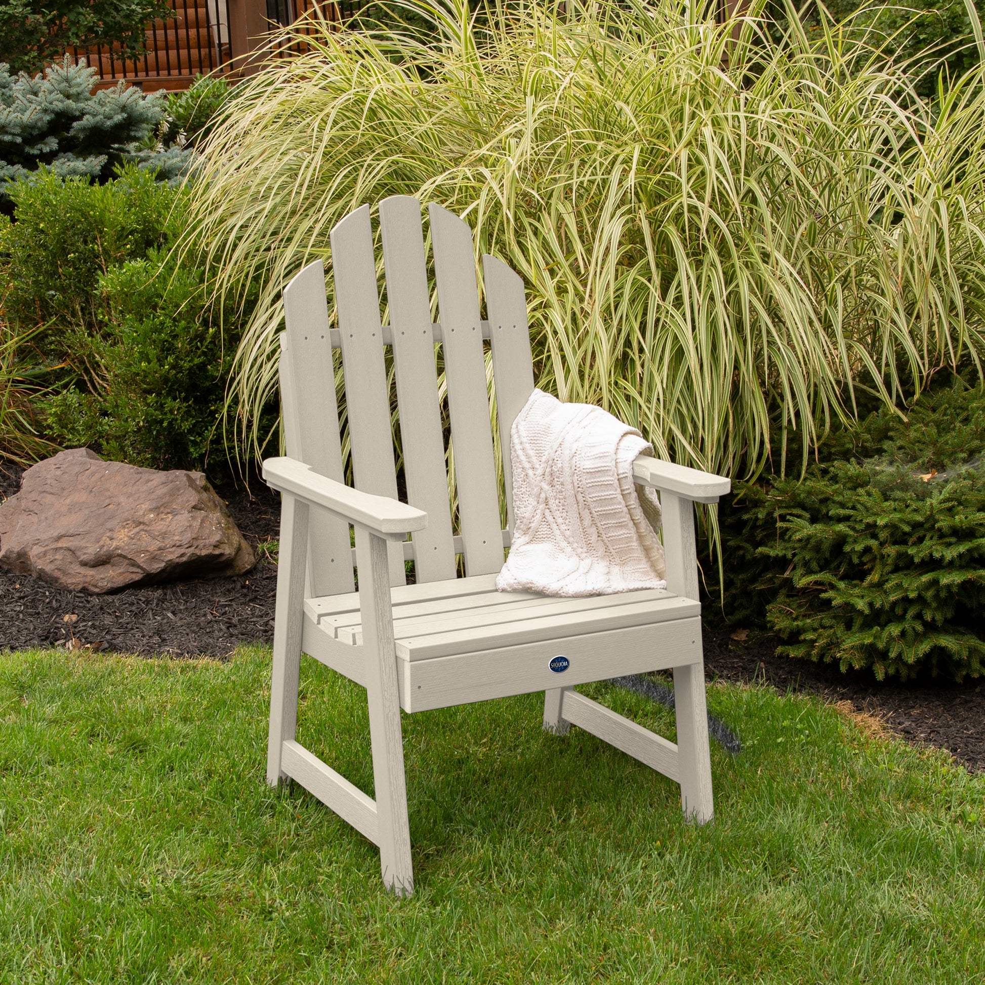 Whitewash Lighthouse Garden Chair on grass in front of bushes
