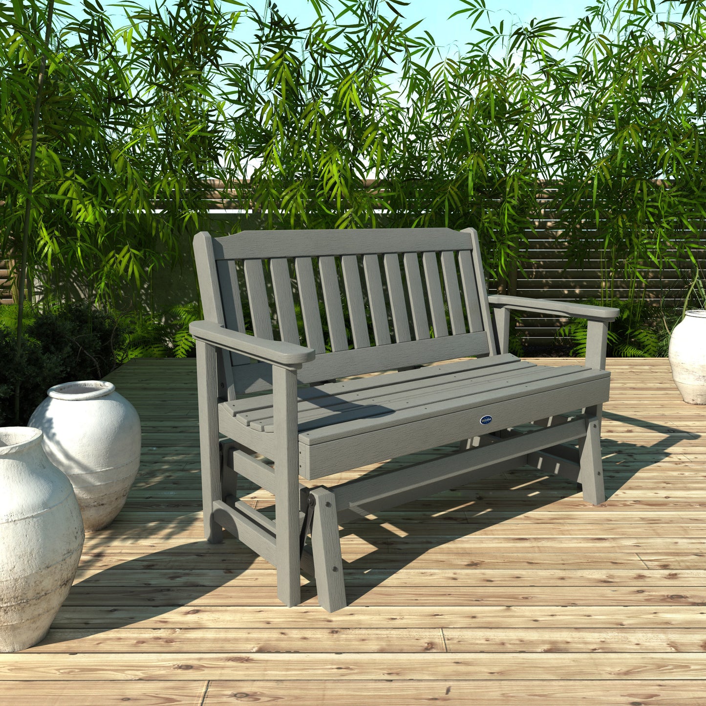 4ft light gray Blue Ridge glider bench on wooden patio with plants in background