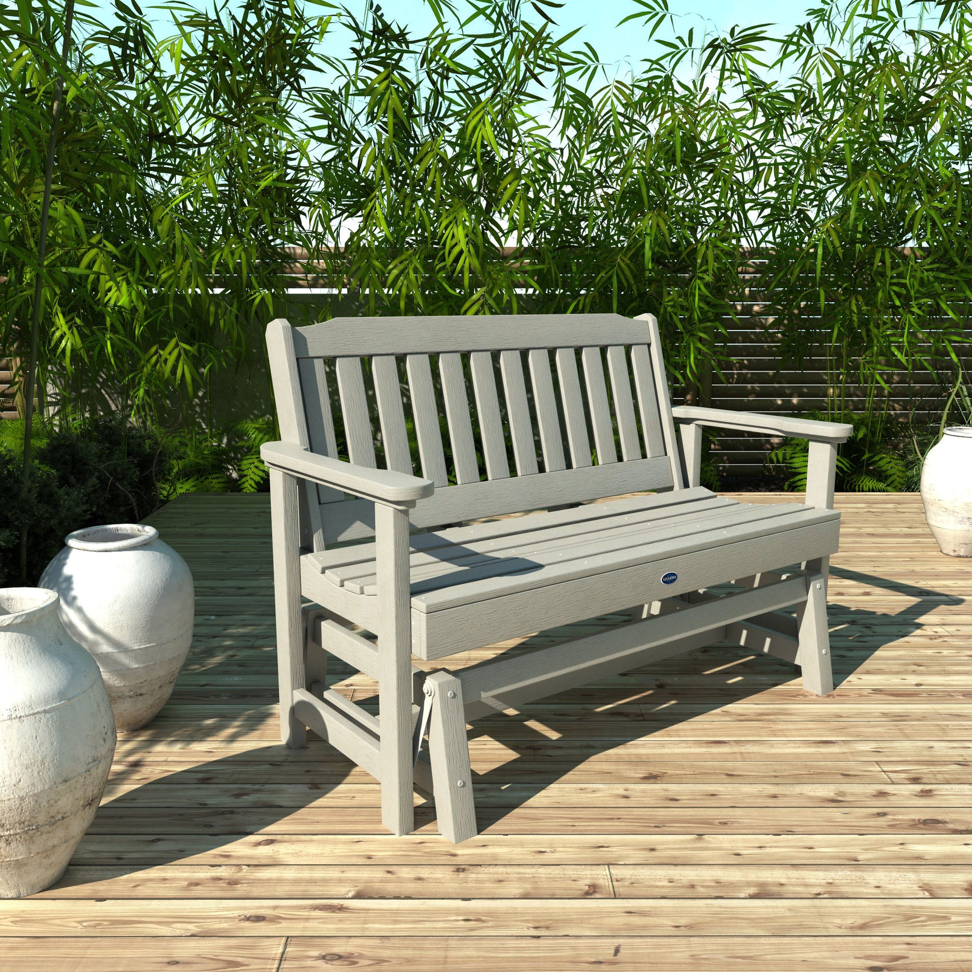 4ft light gray Blue Ridge glider bench on wooden patio with plants in background