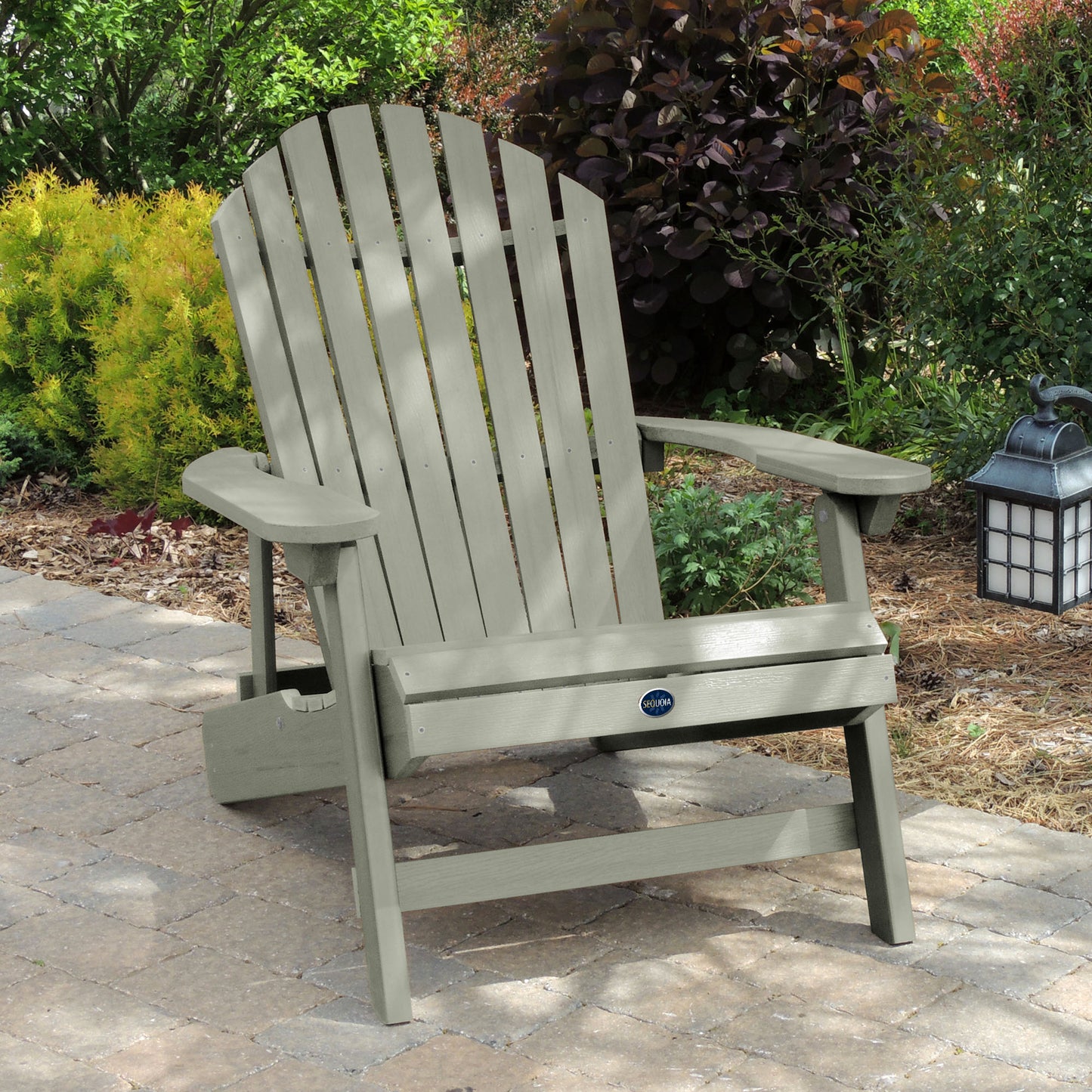 Light green Horizon King-sized Adirondack chair on stone with trees in background