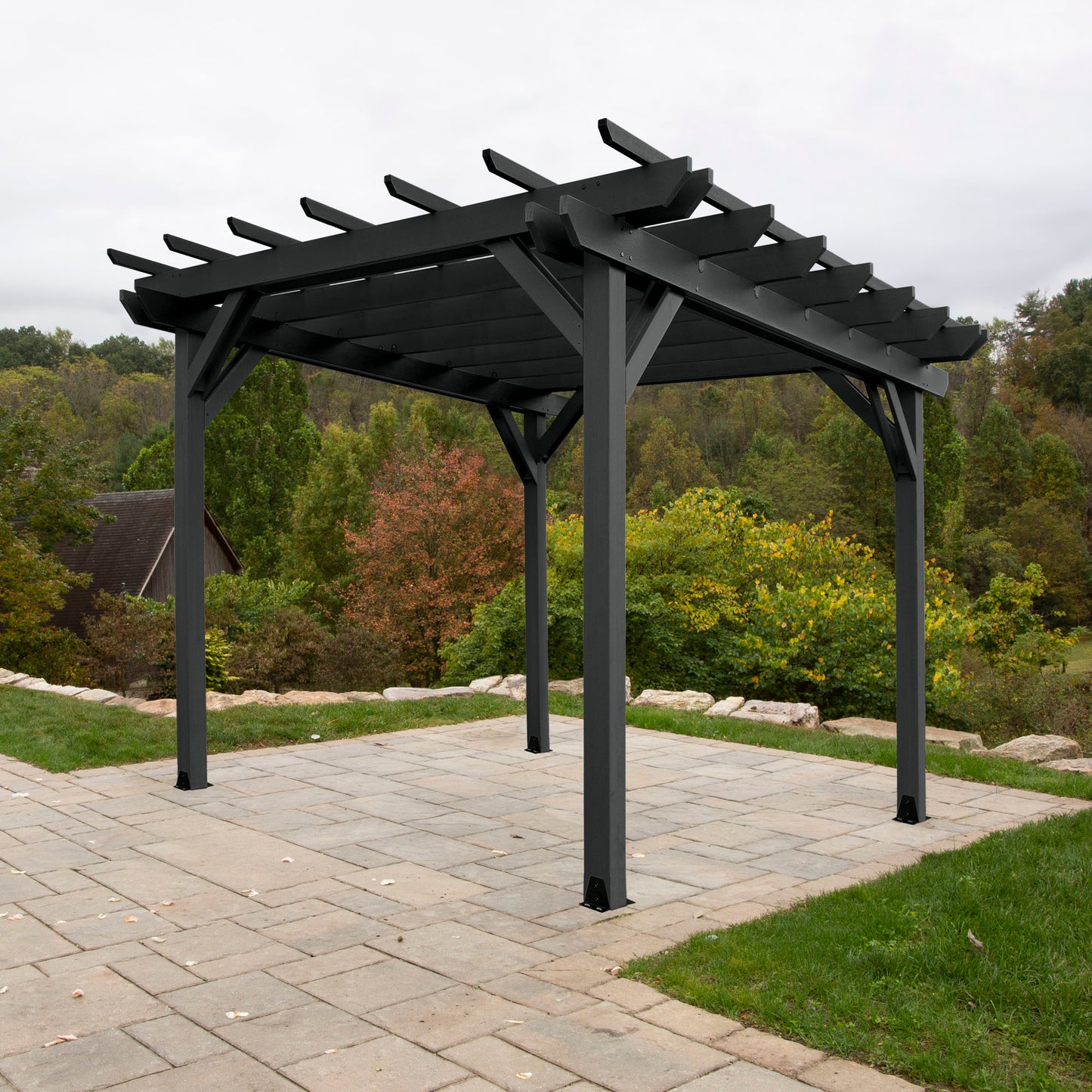 Black St. Clair 12 x 12 Pergola on stone patio with trees in background