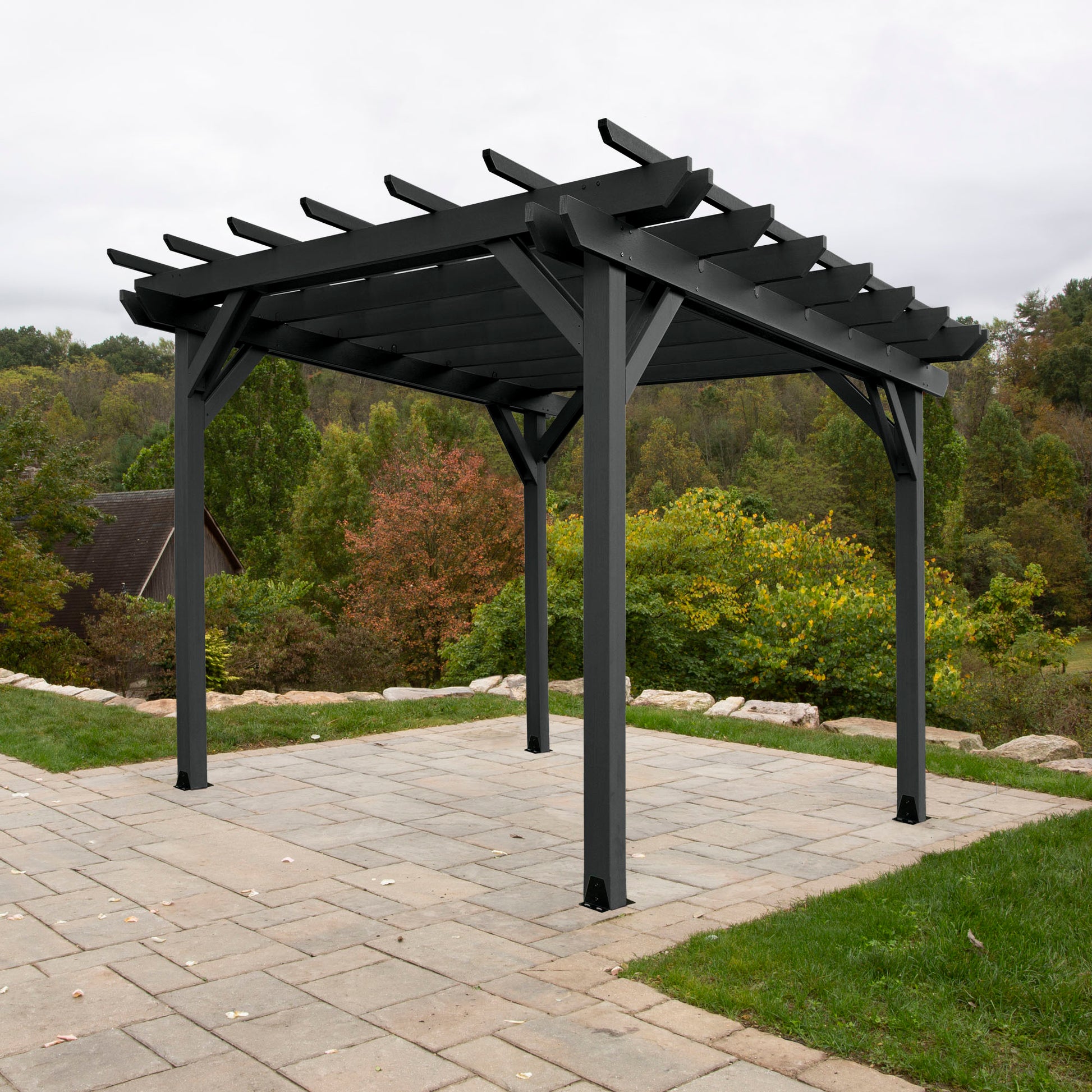 Black St. Clair 12 x 12 Pergola on stone patio with trees in background