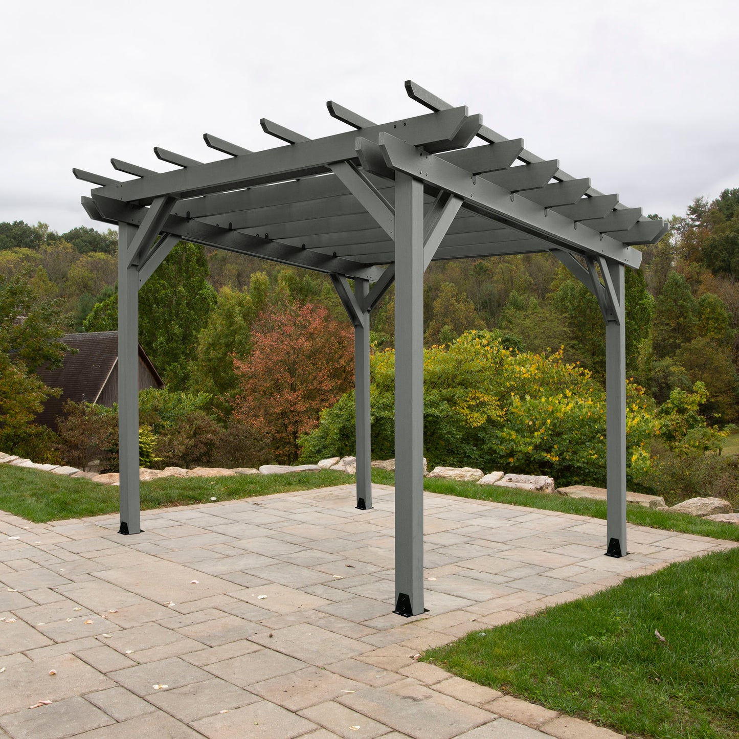 Teak St. Clair 12 x 12 Pergola on stone patio with trees in background