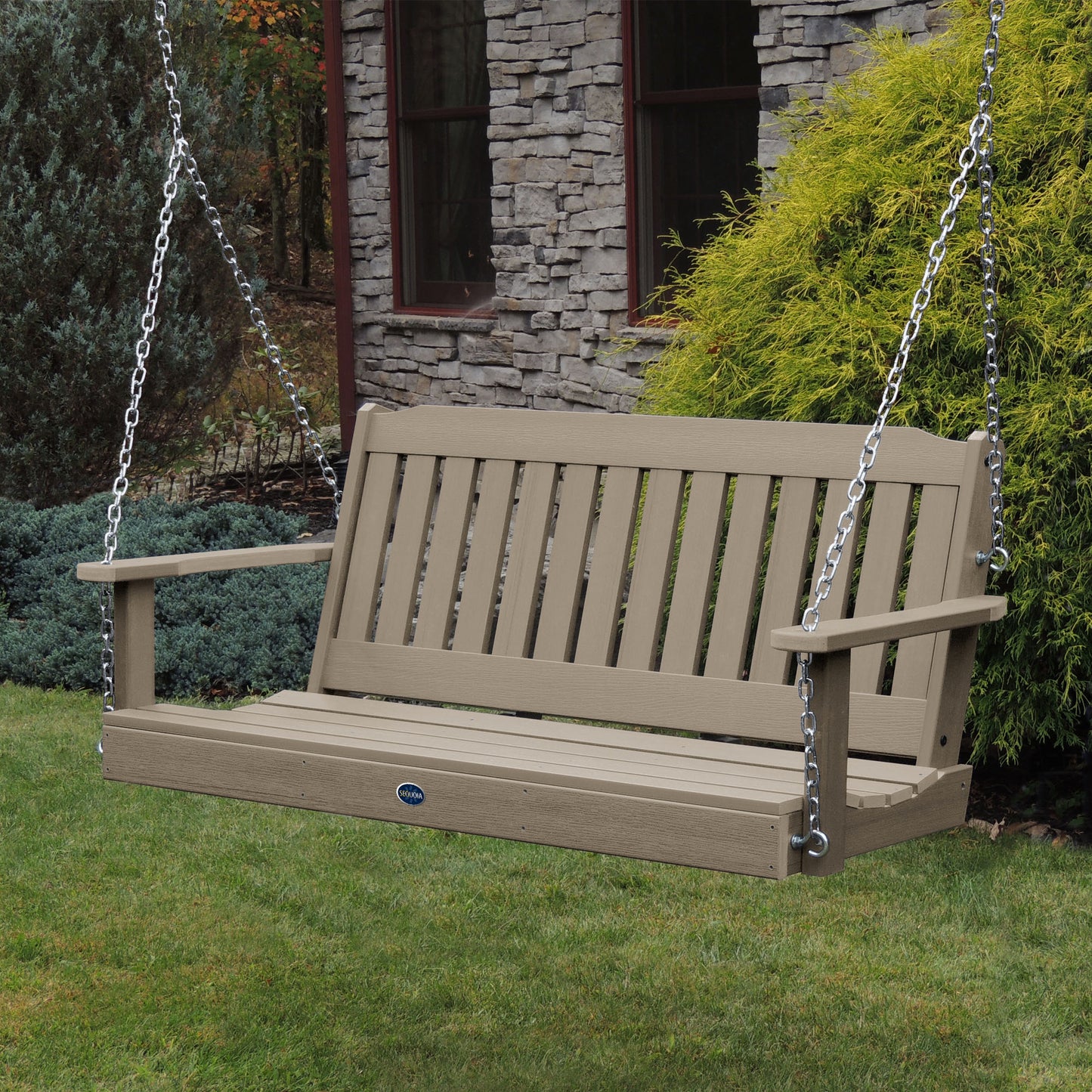 Light brown 5ft Blue Ridge porch swing with stone house in background