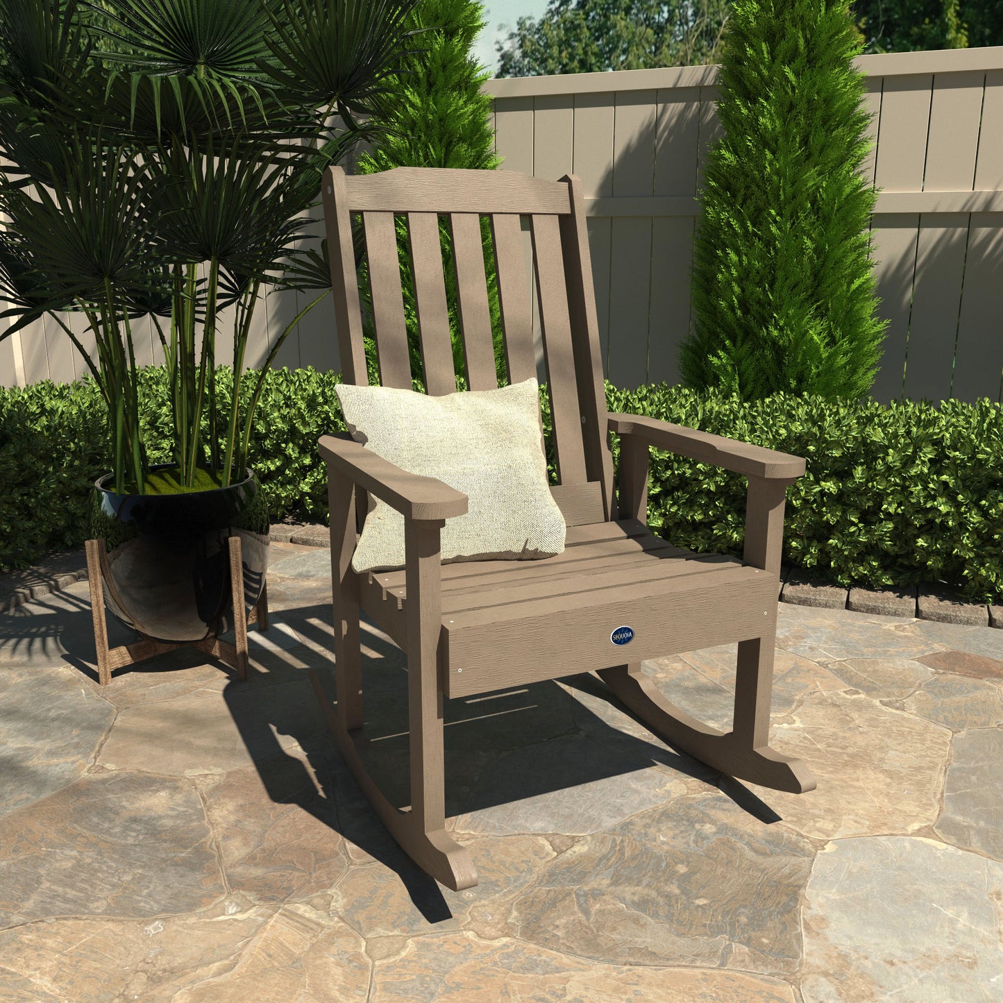 Light brown Blue Ridge rocking chair on stone patio with pillow