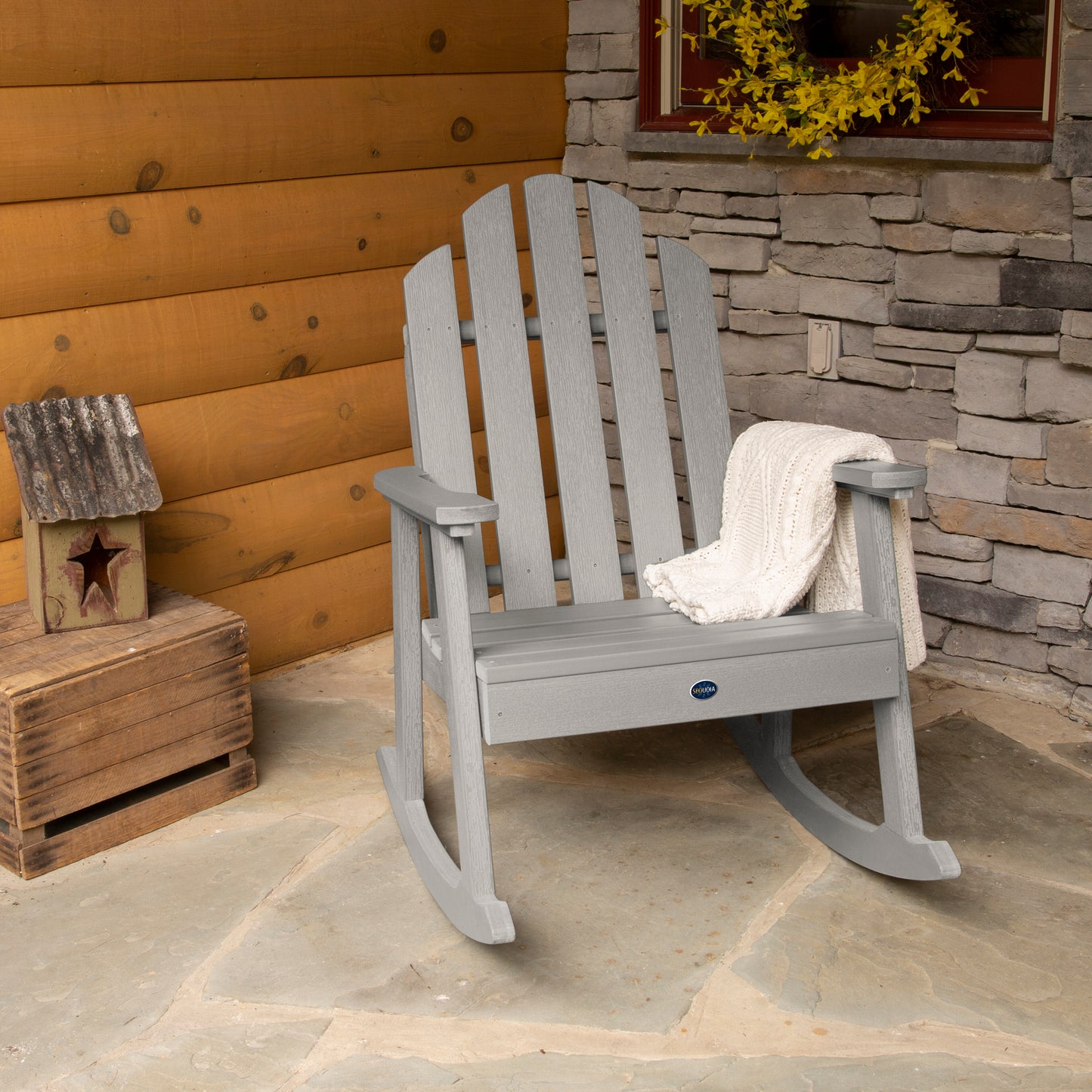 Light gray Lighthouse Garden Rocking Chair on porch with blanket