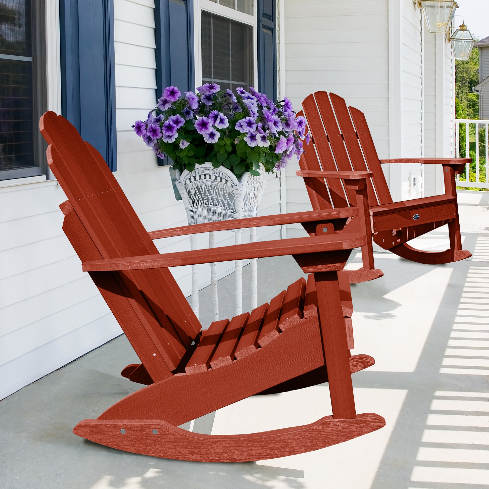Two red Lighthouse Adirondack rocking chairs on front porch with flowers