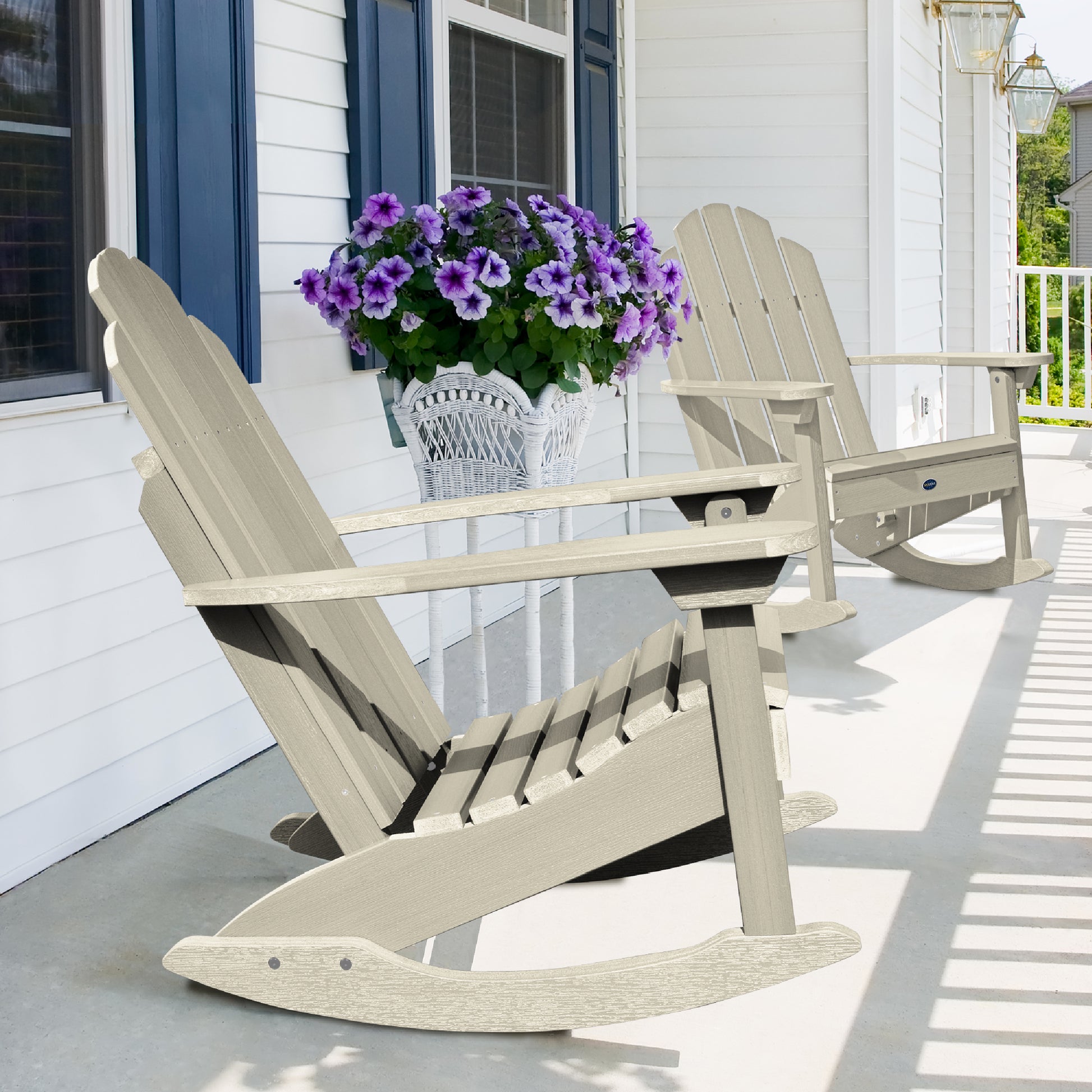 Two whitewash Lighthouse Adirondack rocking chairs on front porch with flowers