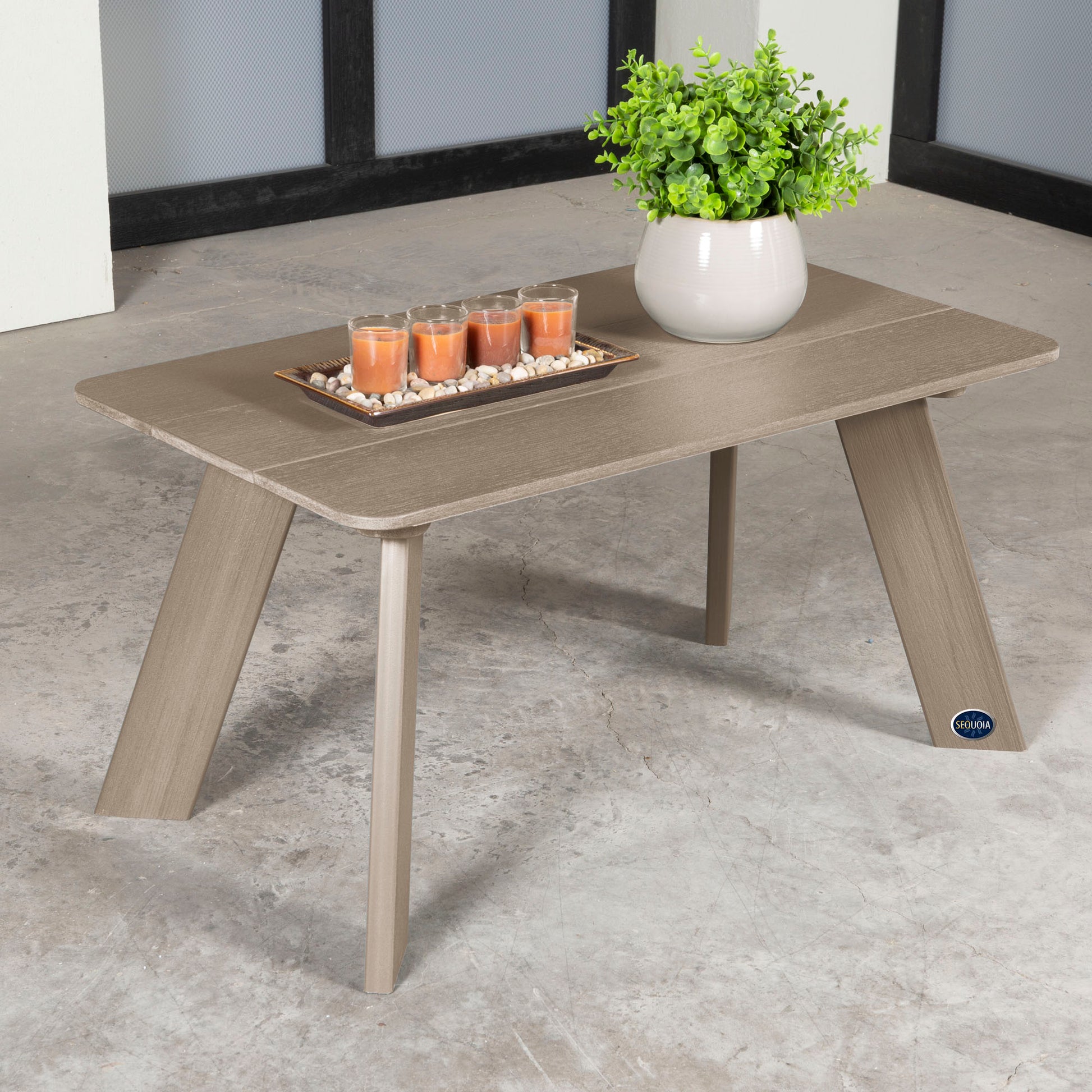 Light brown Granite Hills coffee table with candles and plant