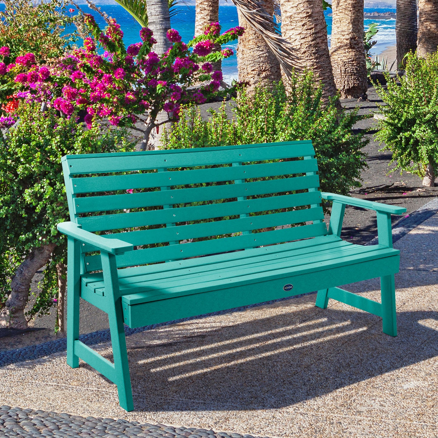 Blue Sunrise Coast 5ft bench in front of flowers on walkway