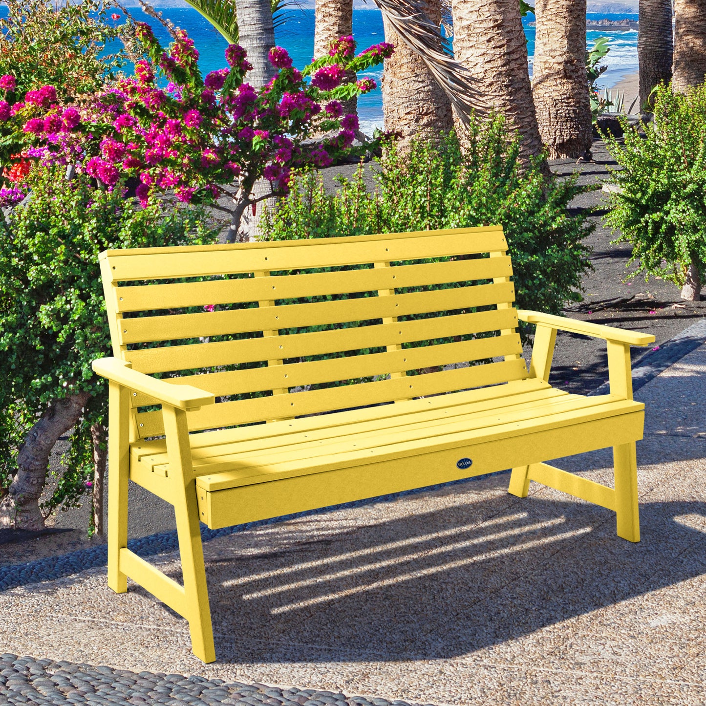 Yellow Sunrise Coast 5ft bench in front of flowers on walkway
