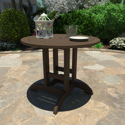 Brown 36” diameter dining height table with lantern, plates, and glasses