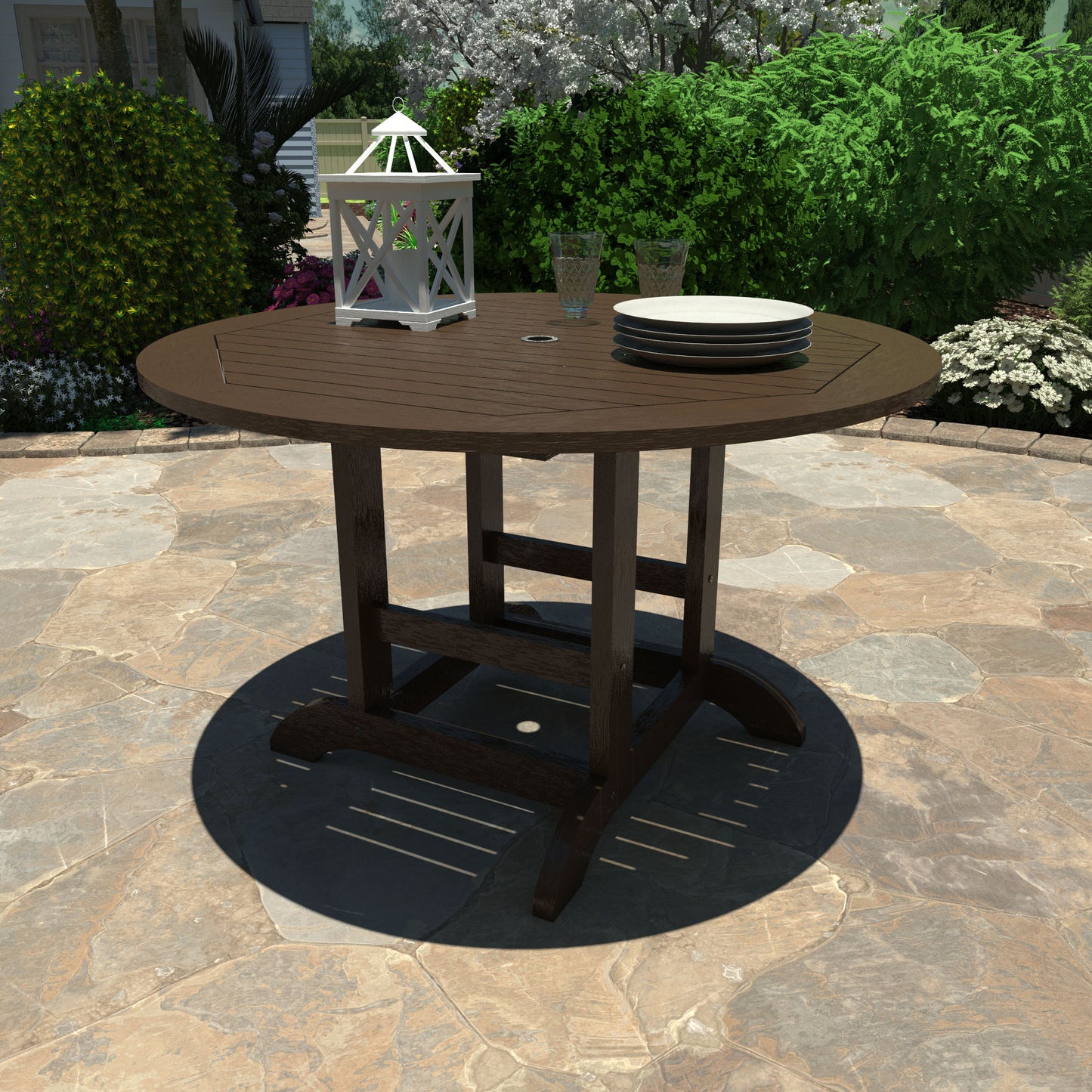 Brown 48in diameter dining height table with lantern, plates, and glasses