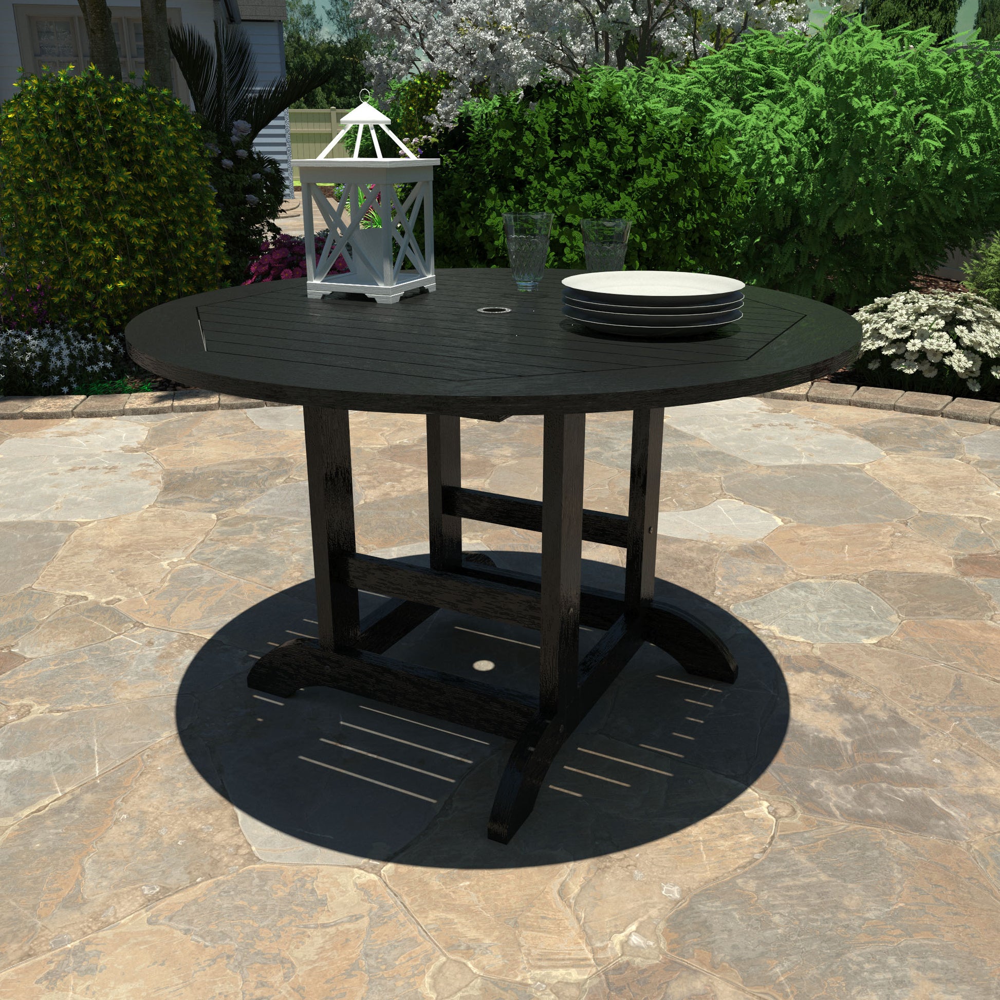 Black 48in diameter dining height table with lantern, plates, and glasses