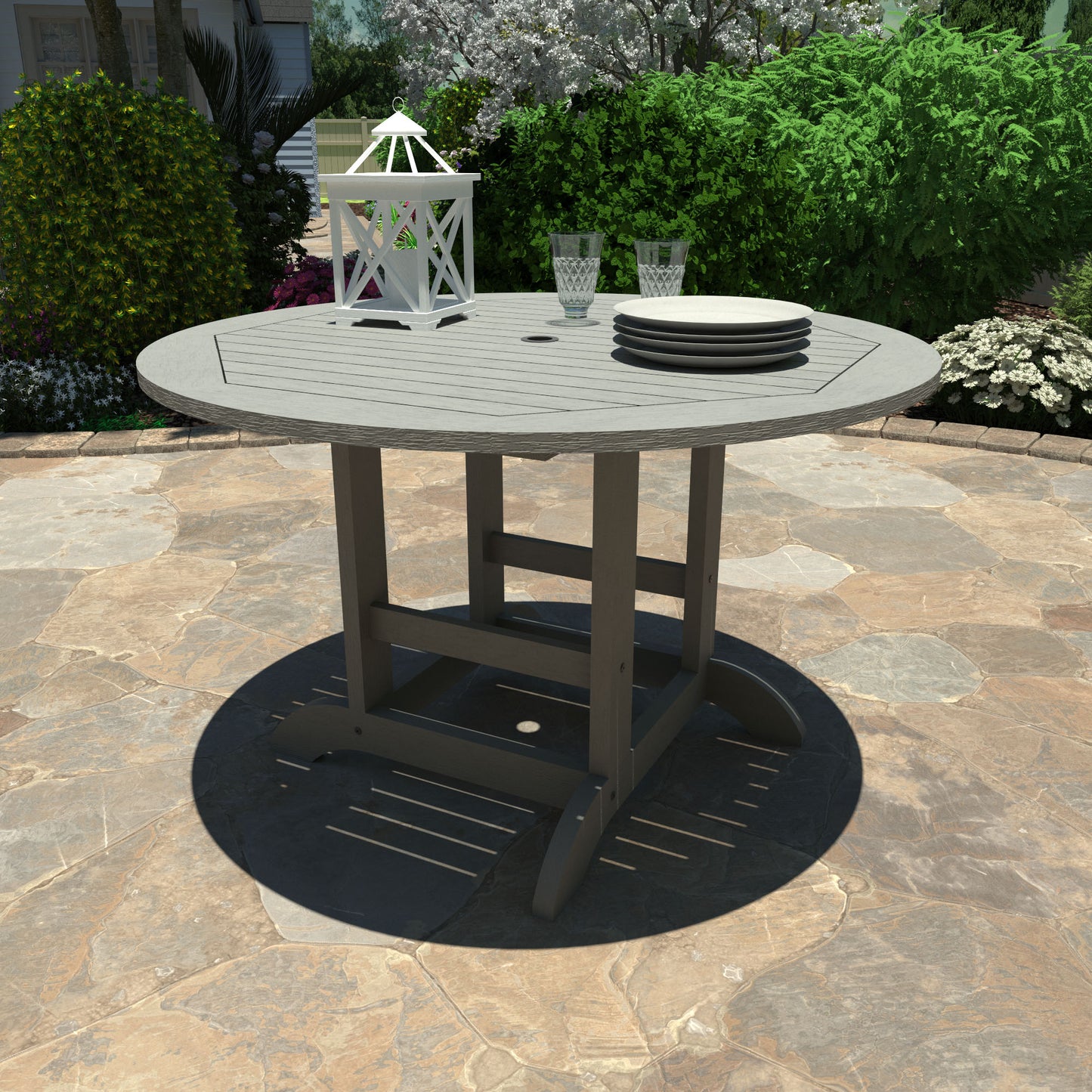 Gray 48in diameter dining height table with lantern, plates, and glasses