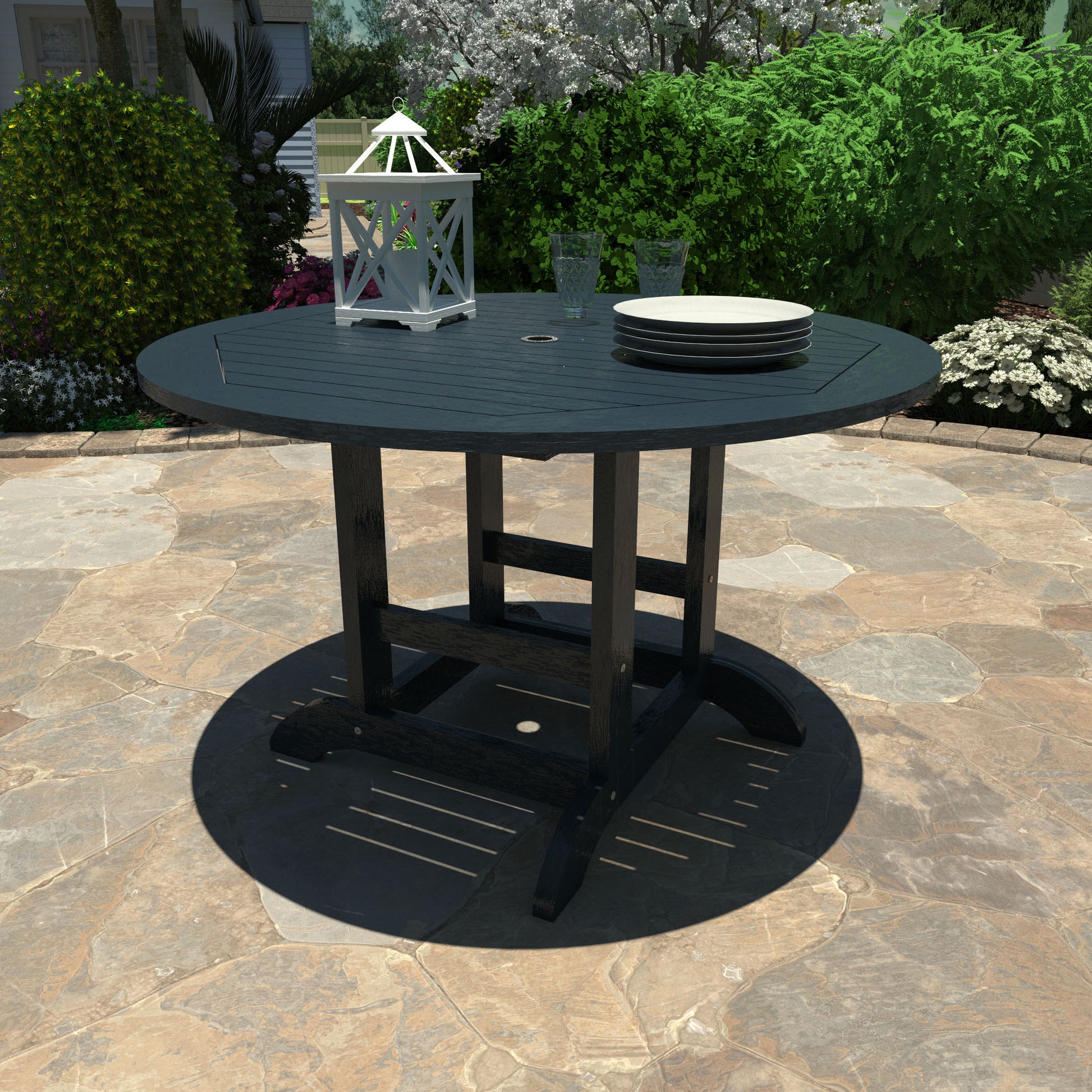 Dark blue 48in diameter dining height table with lantern, plates, and glasses