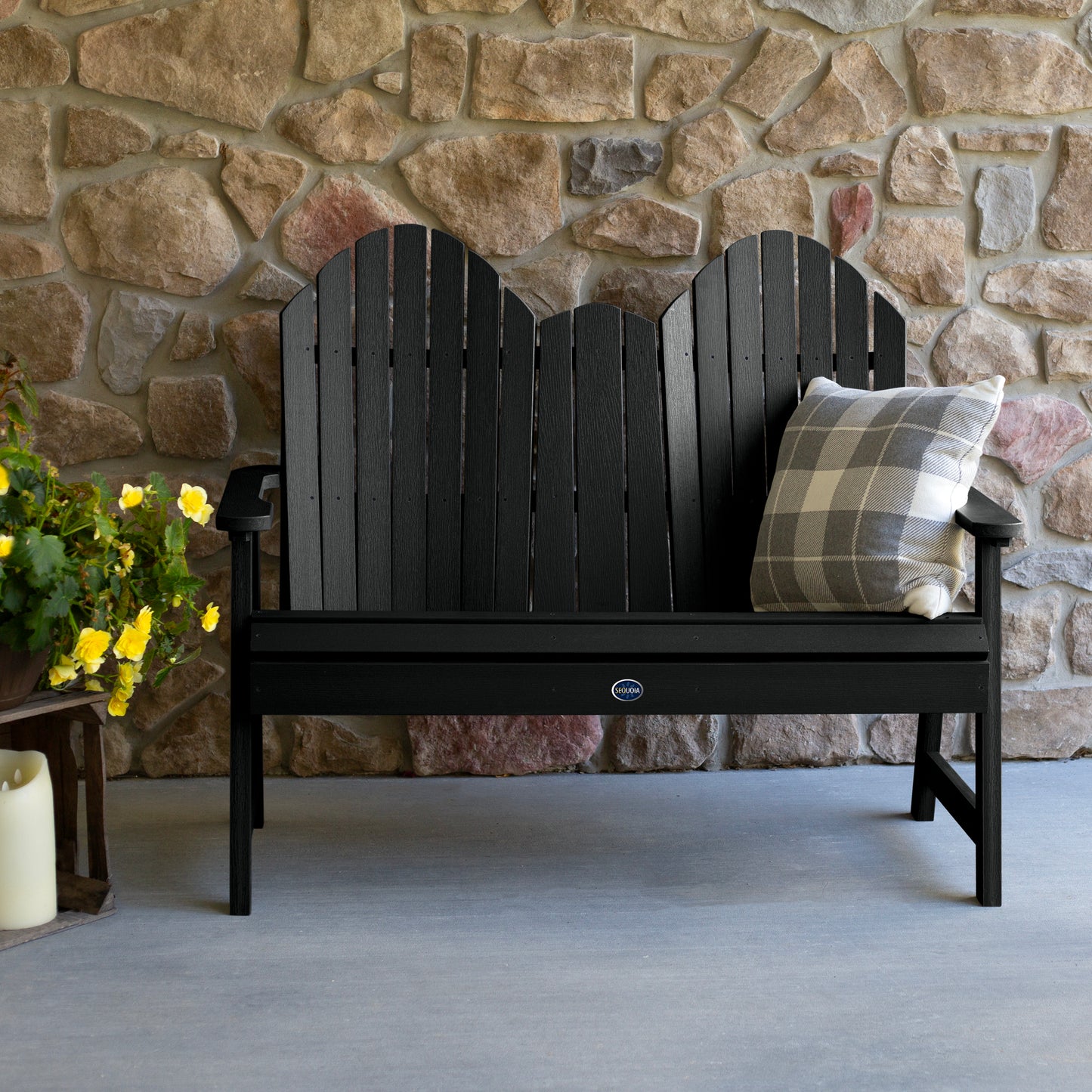 Black Lighthouse Adirondack bench against stone wall