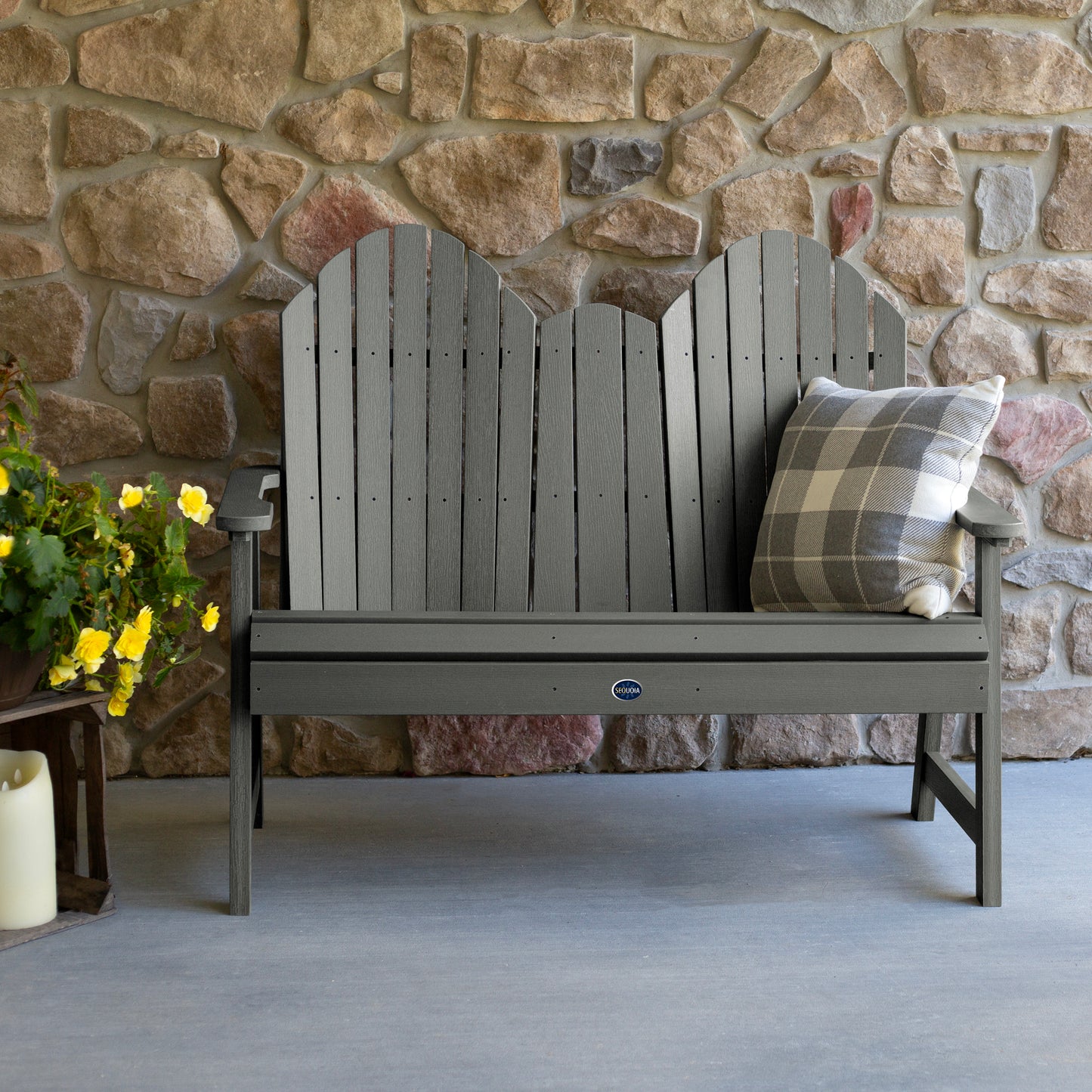 Gray Lighthouse Adirondack bench against stone wall