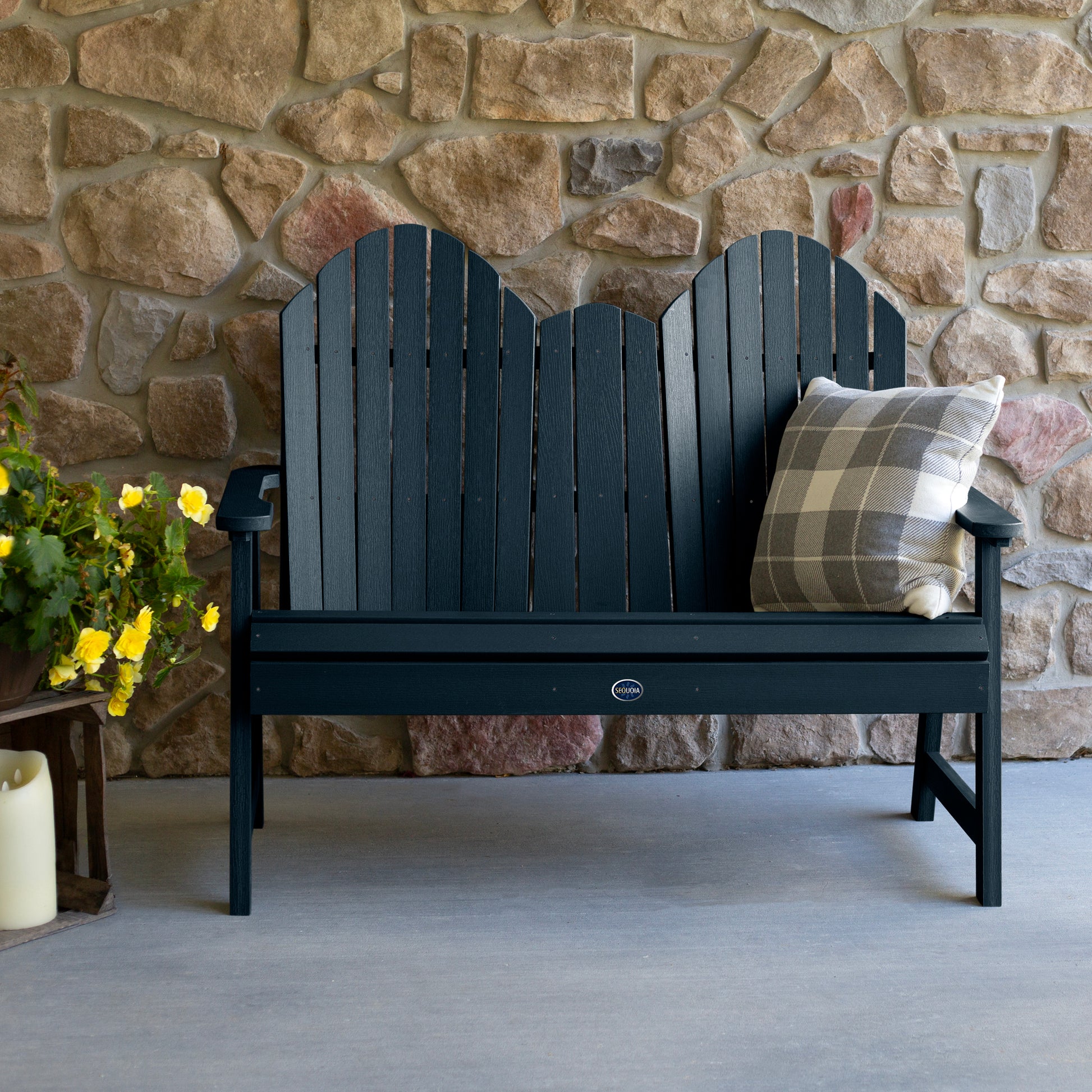 Dark blue Lighthouse Adirondack bench against stone wall