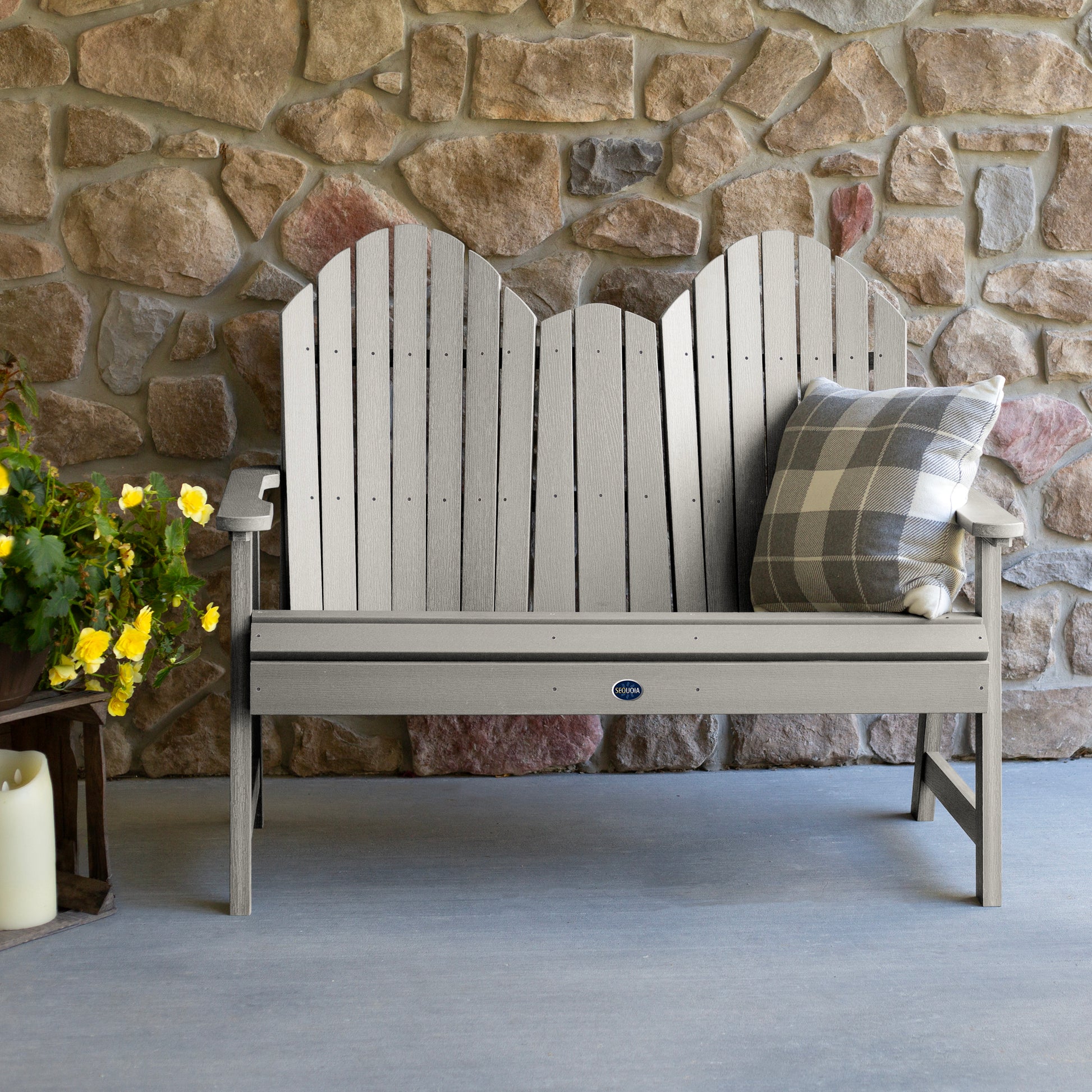 Light gray Lighthouse Adirondack bench against stone wall