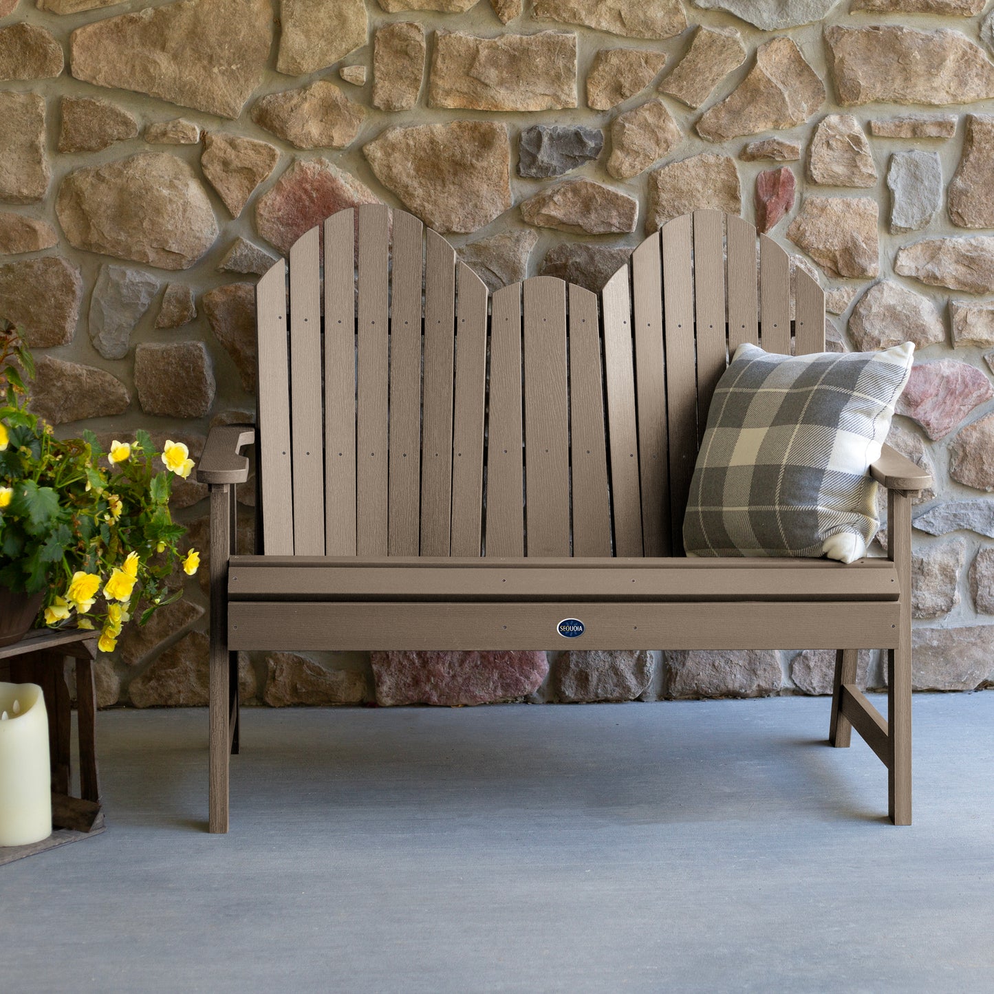 Light brown Lighthouse Adirondack bench against stone wall