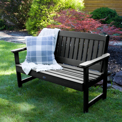 4ft black Blue Ridge garden bench on grass with blanket and pillow