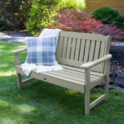 4ft light green Blue Ridge garden bench on grass with blanket and pillow