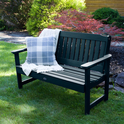 4ft dark blue Blue Ridge garden bench on grass with blanket and pillow