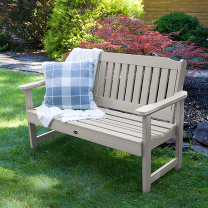 4ft light gray Blue Ridge garden bench on grass with blanket and pillow