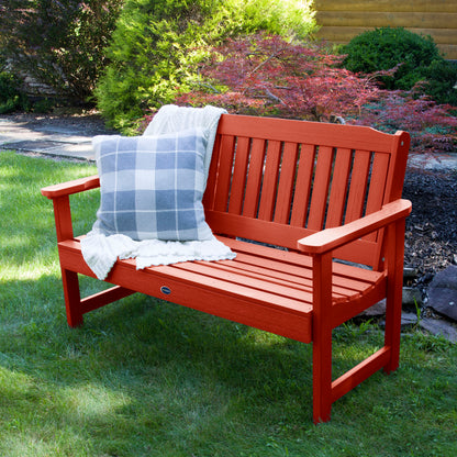 4ft red Blue Ridge garden bench on grass with blanket and pillow