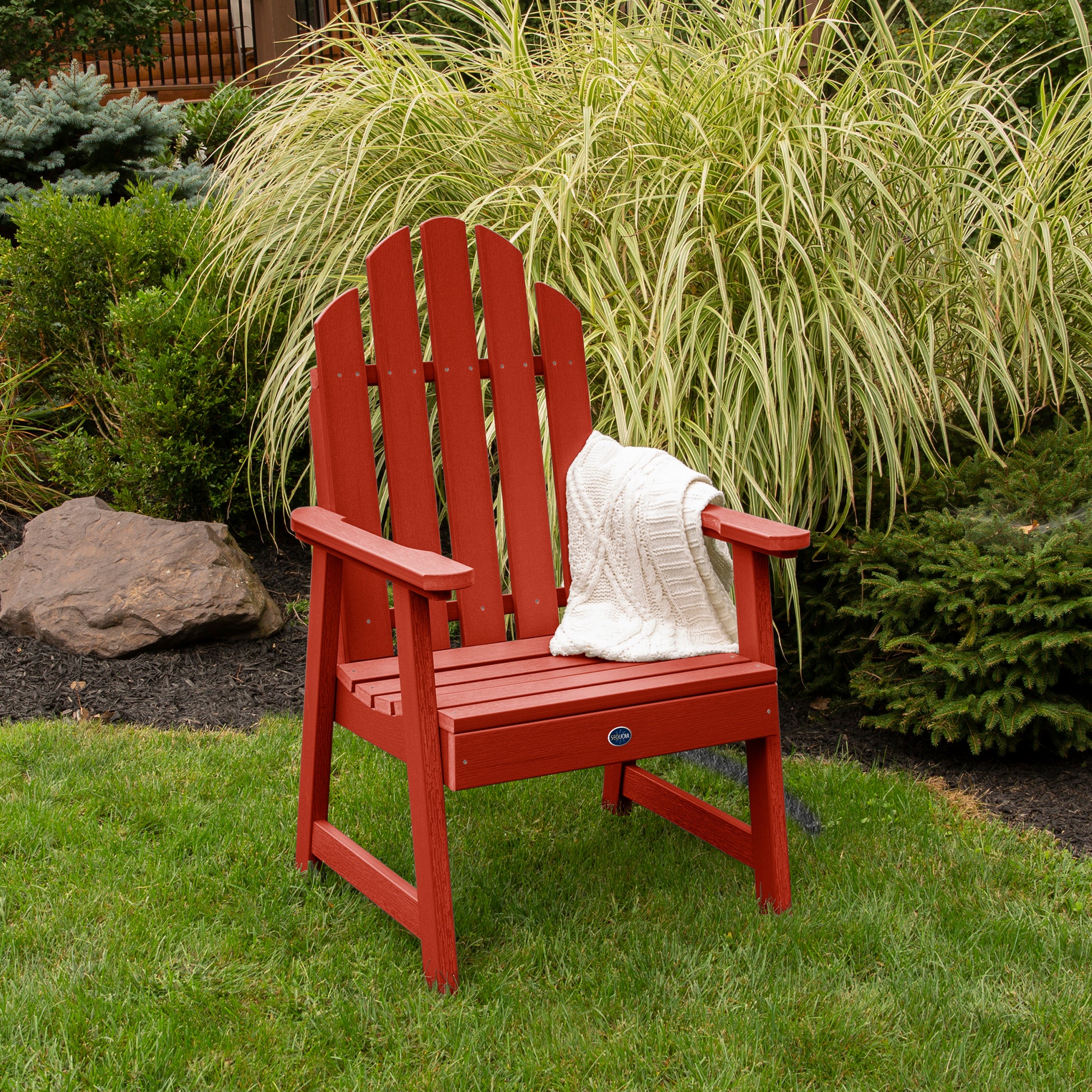 Red Lighthouse Garden Chair on grass in front of bushes