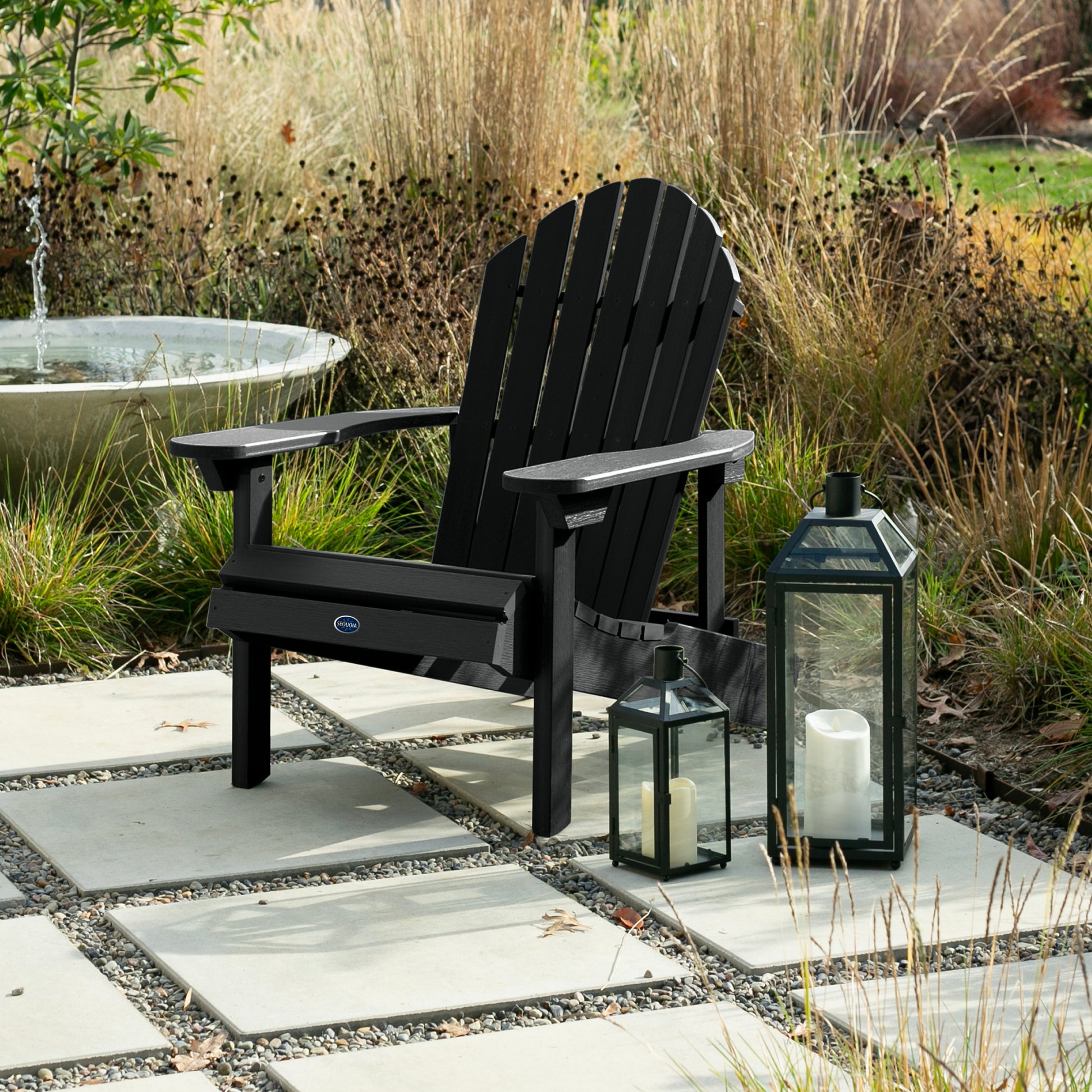 Black Horizon Adirondack chair on stone next to lanterns