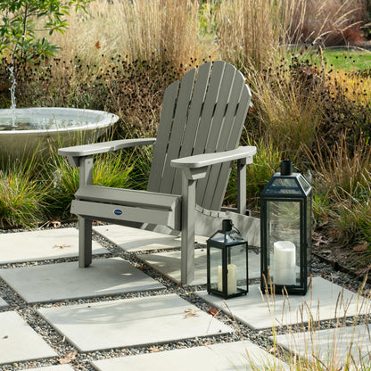Light green Horizon Adirondack chair on stone next to lanterns