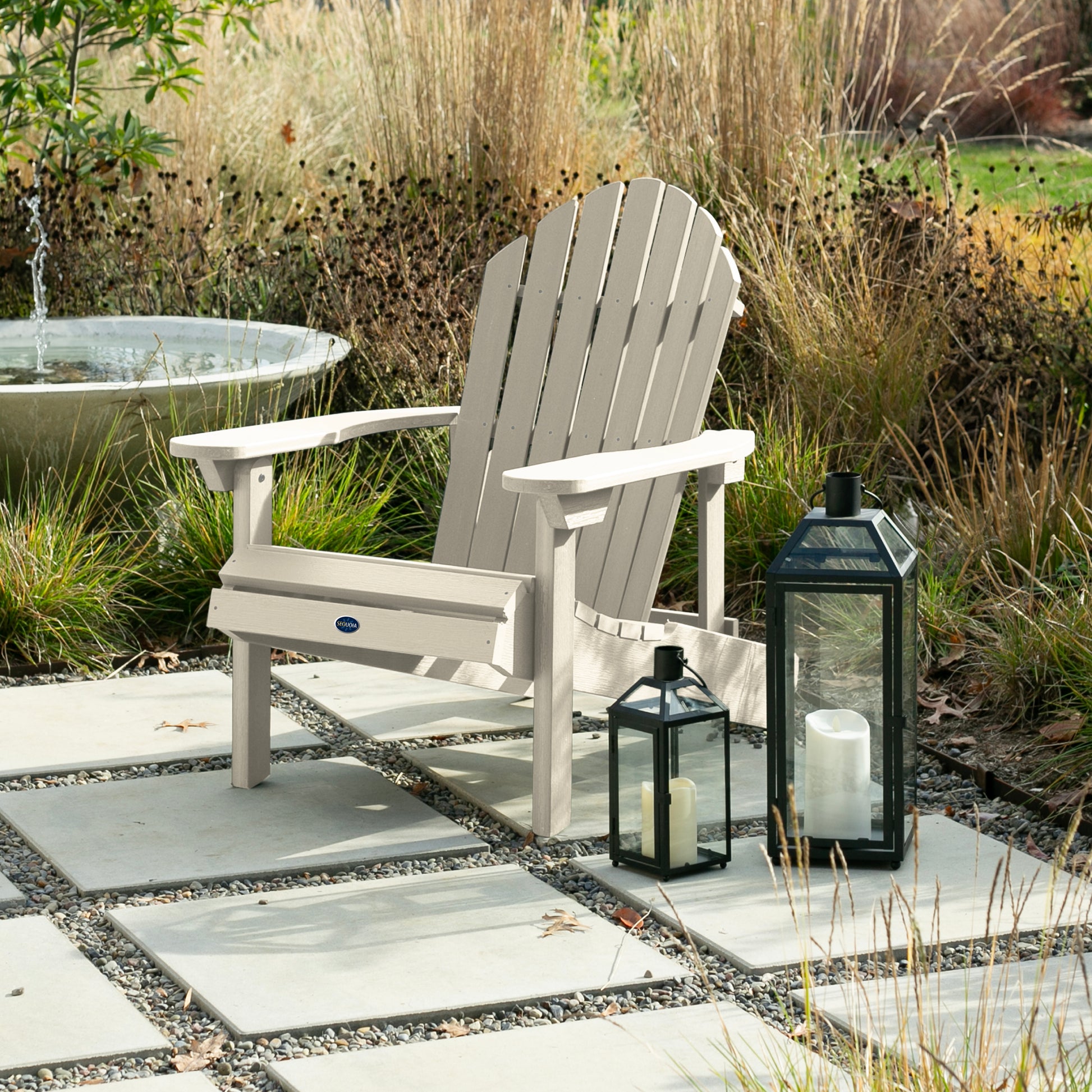 Whitewash Horizon Adirondack chair on stone next to lanterns