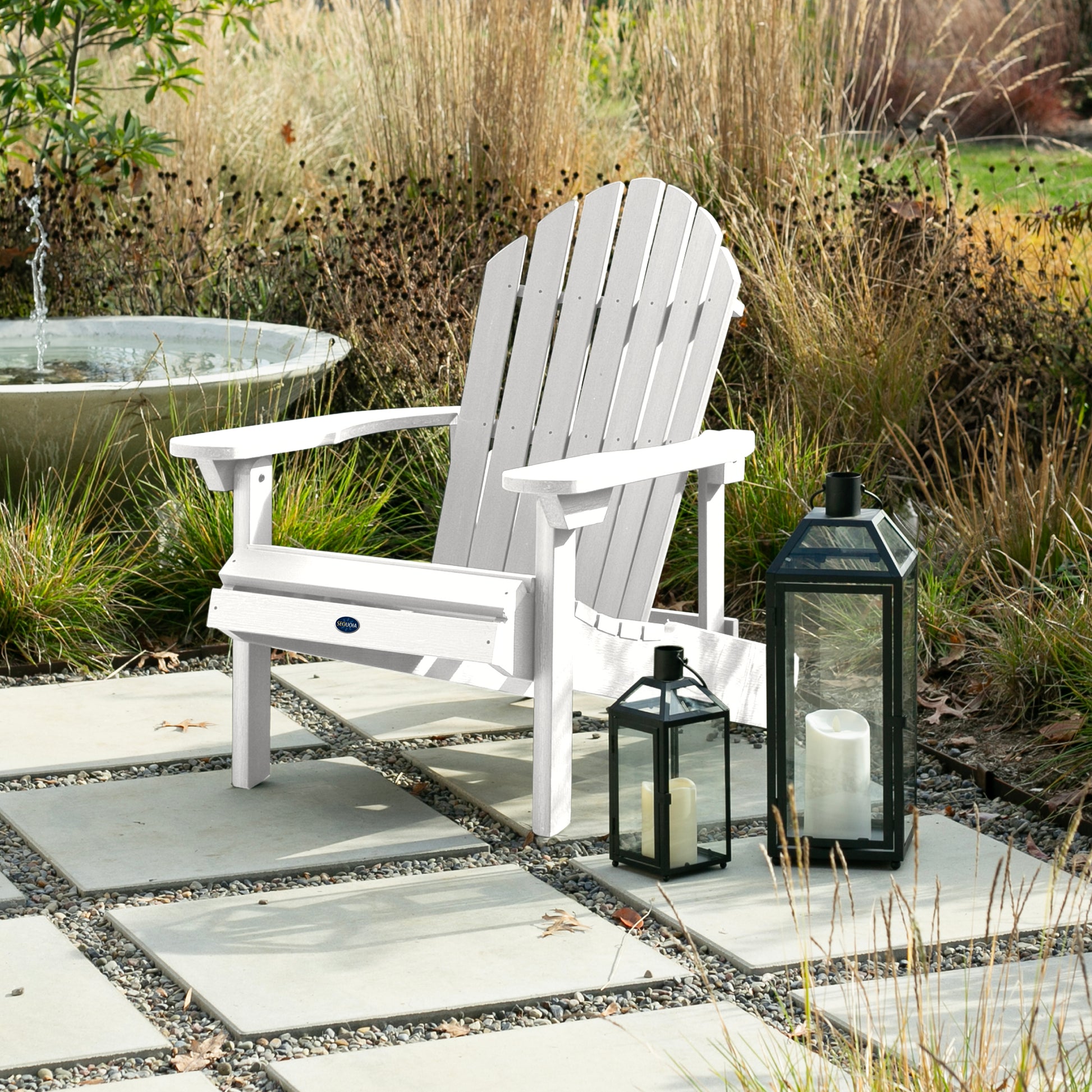 White Horizon Adirondack chair on stone next to lanterns