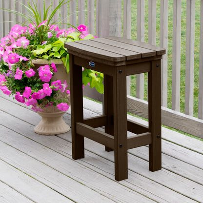 Brown Blue Ridge counter height stool on tan wooden deck next to flowers