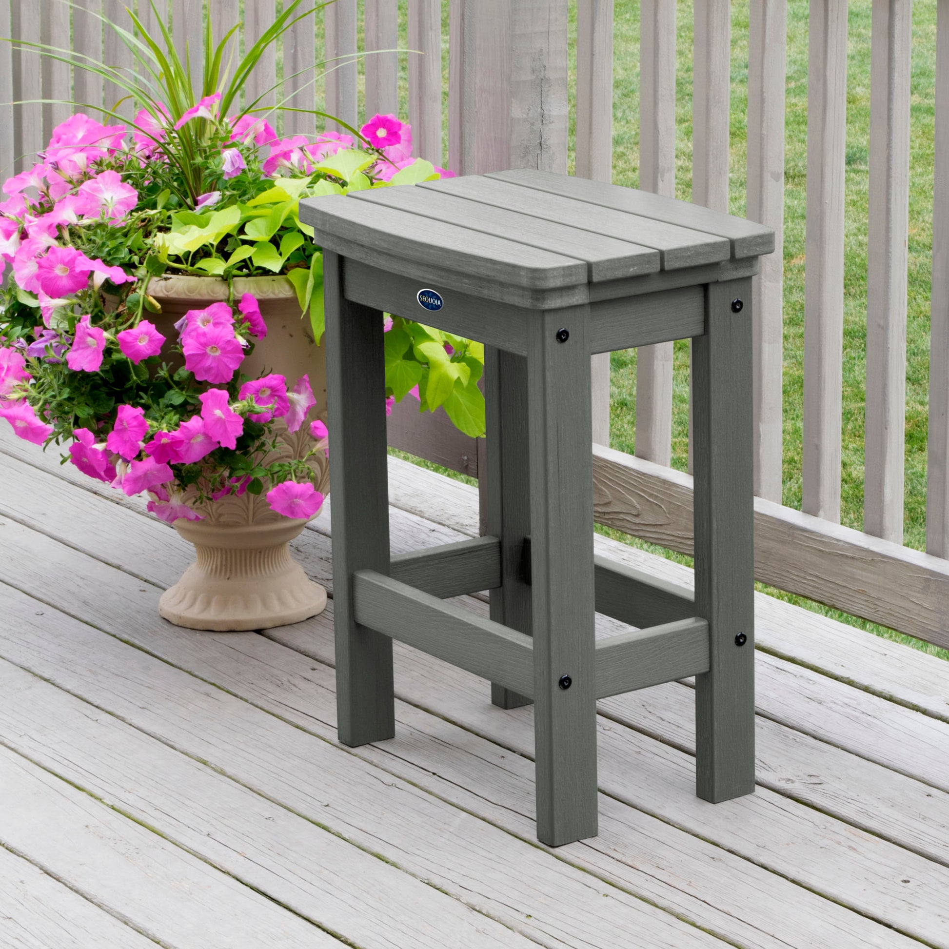 Gray Blue Ridge counter height stool on tan wooden deck next to flowers