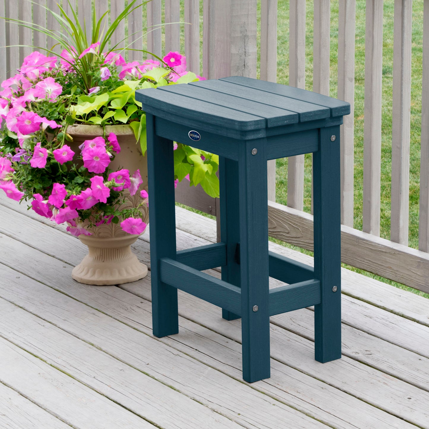 Light blue Blue Ridge counter height stool on tan wooden deck next to flowers