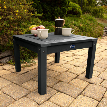 Black Adirondack side table with coffee and fruit bowl